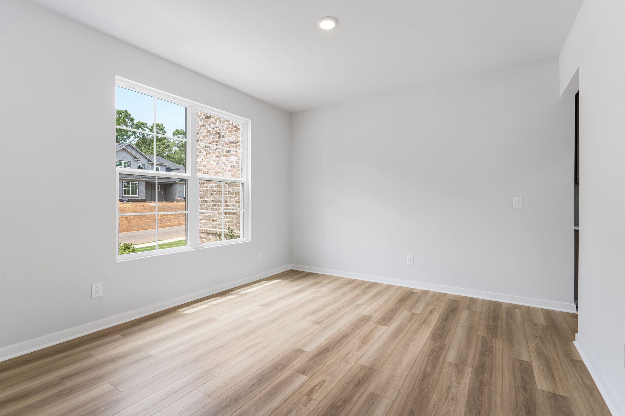 A room with a wood floor and a window with a wood floor.