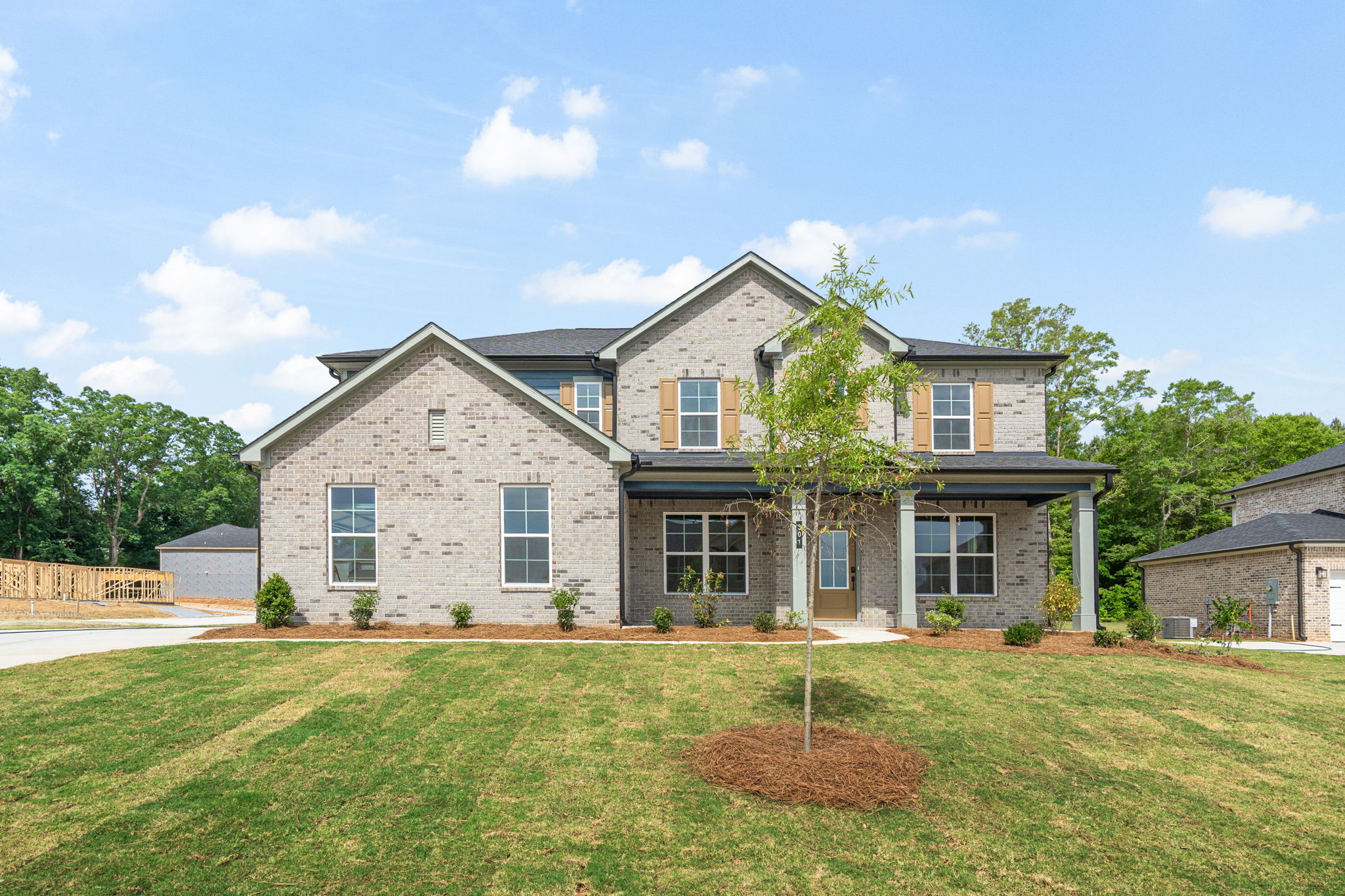 A large brick house with a tree in the front yard.
