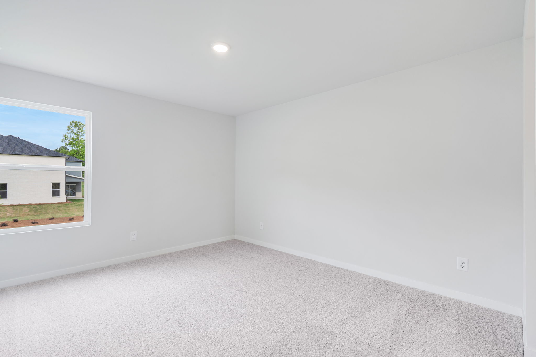 A room with a white wall and a window.