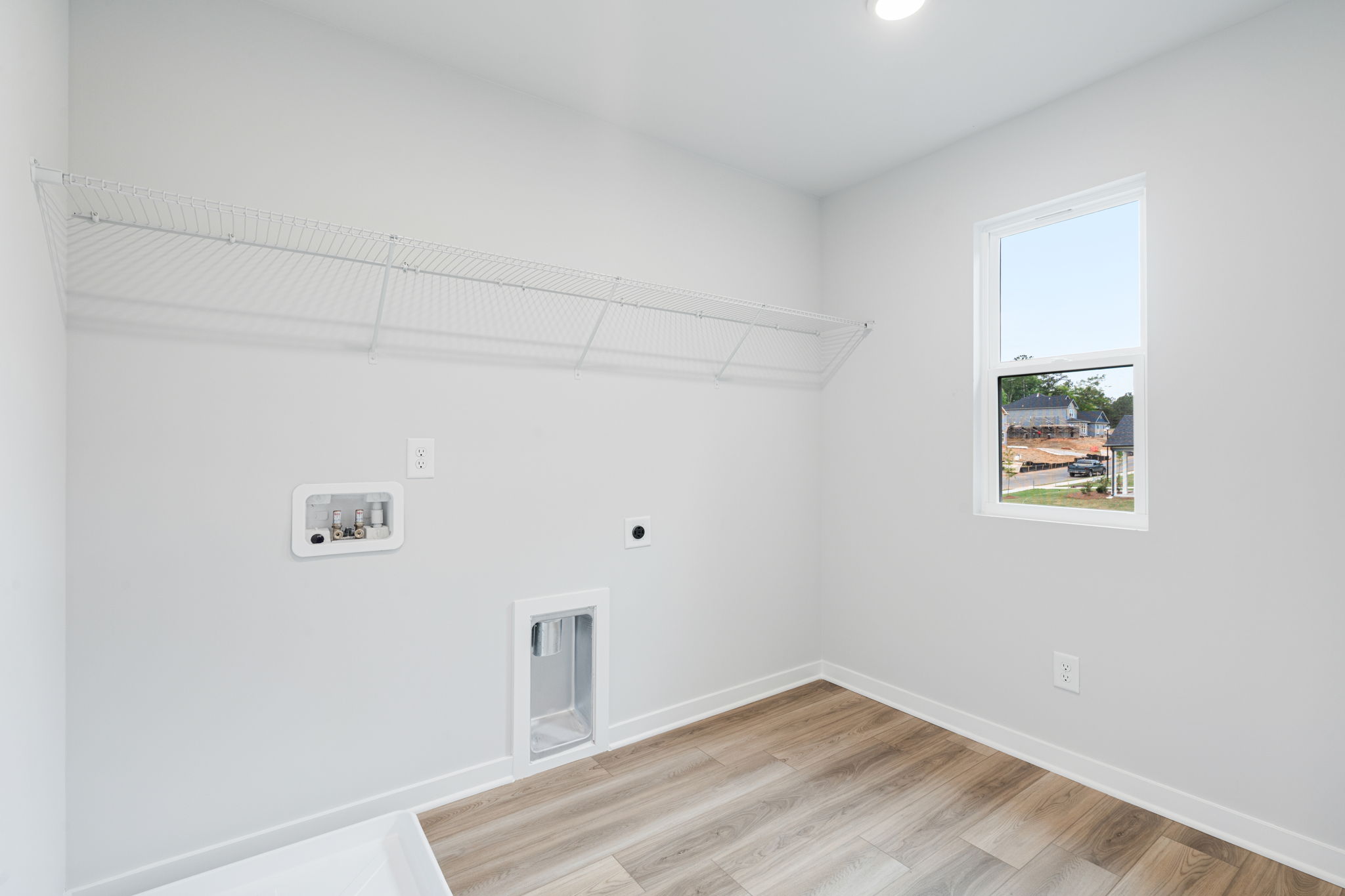 A room with a wood floor and a window with a wood floor.