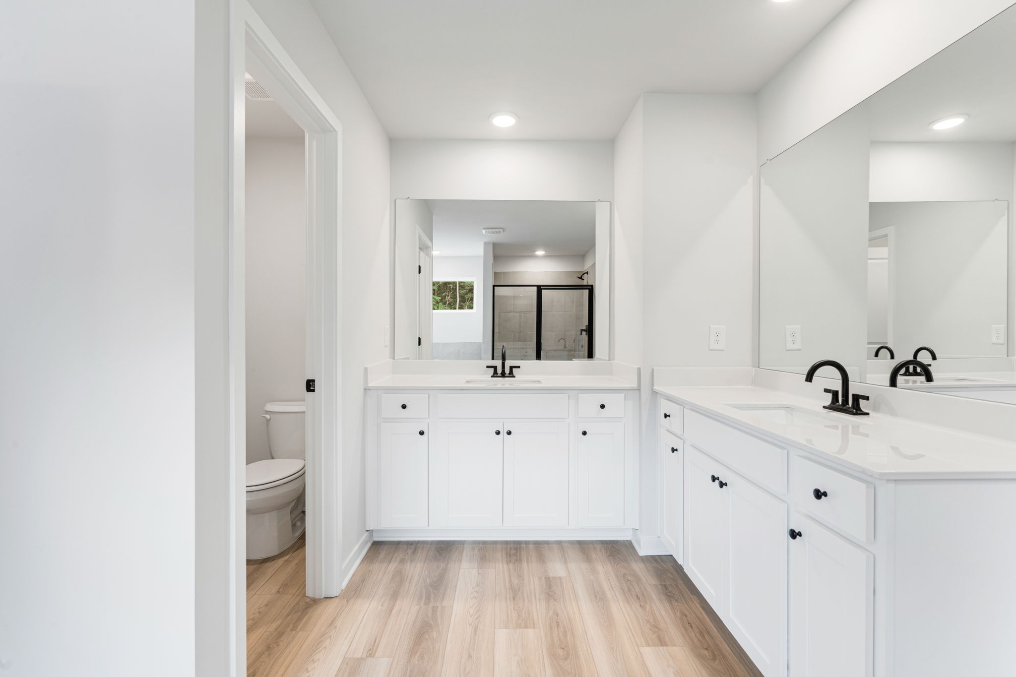 A bathroom with white cabinets.