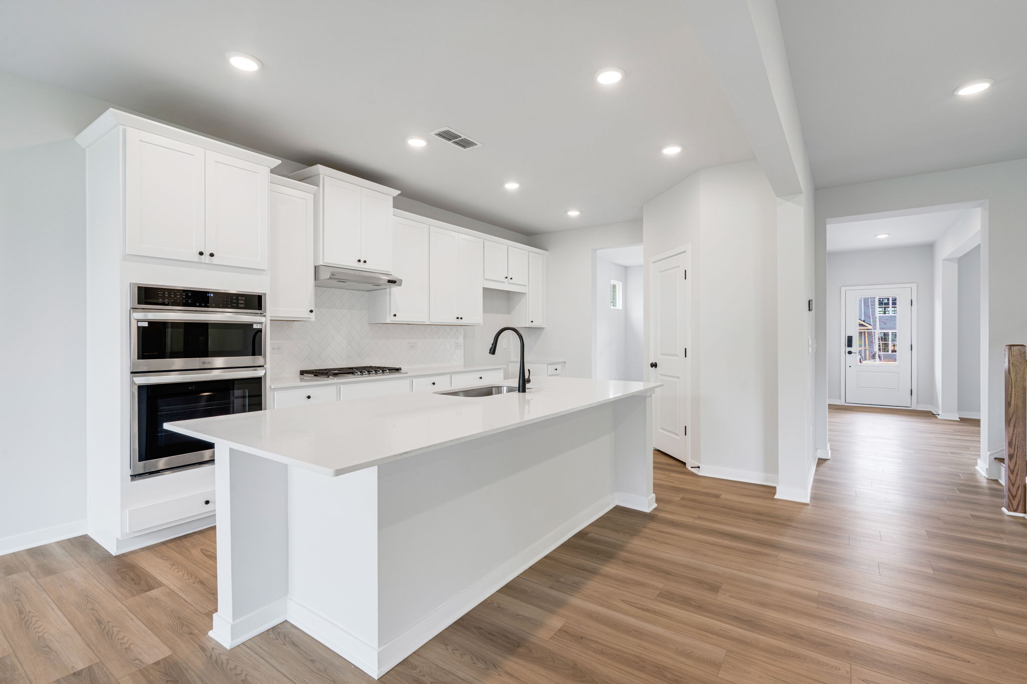 A kitchen with white cabinets.
