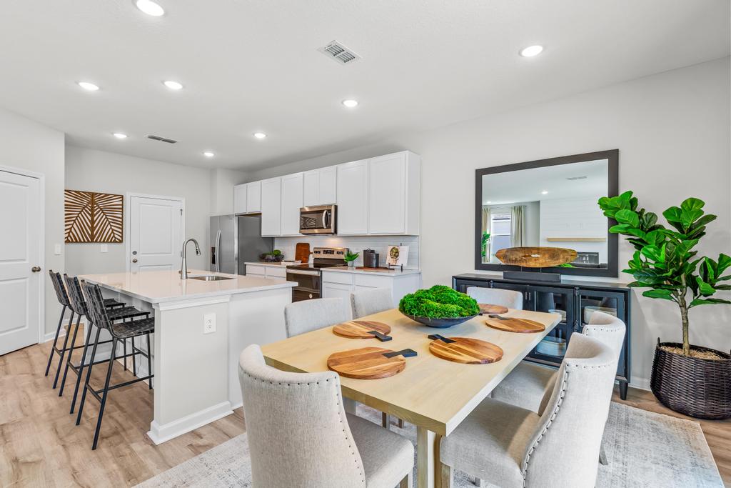 A kitchen with a dining table and chairs.