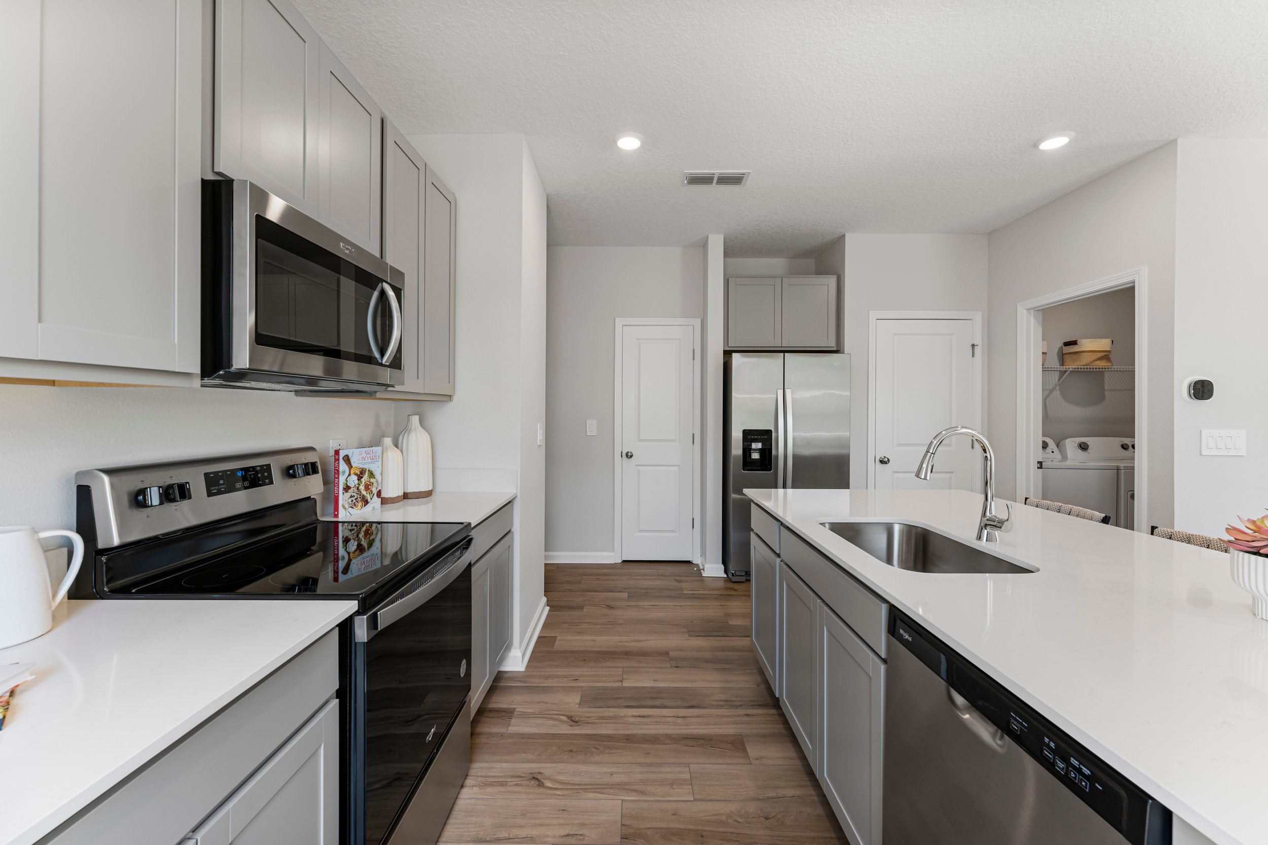 Sanibel Model Home Kitchen with White Quartz Counters at The Landings at Pecan Park in Jacksonville