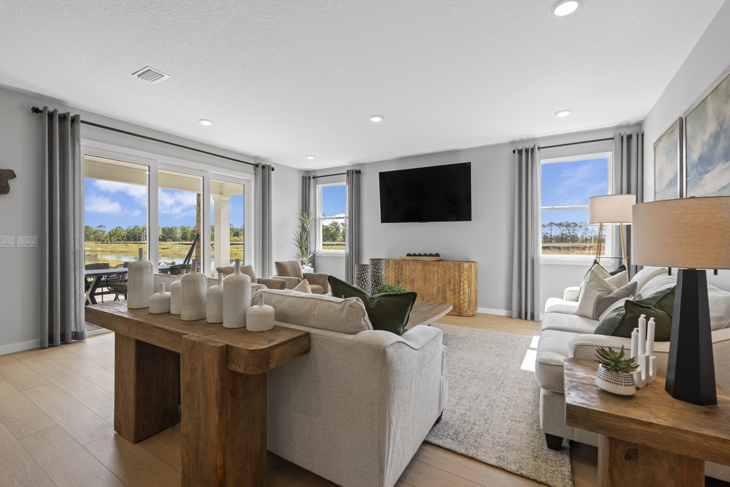 Kenai Model Home Living Room with Large Patio Doors at Reserve East in Flagler Beach
