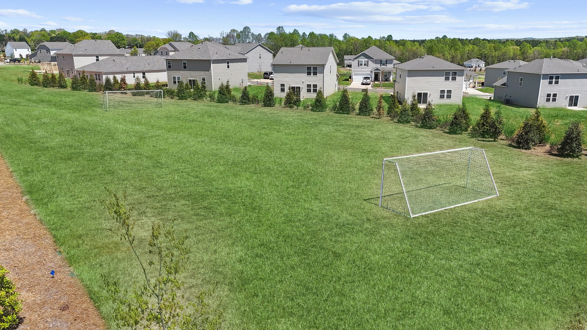 A football field with houses in the background.