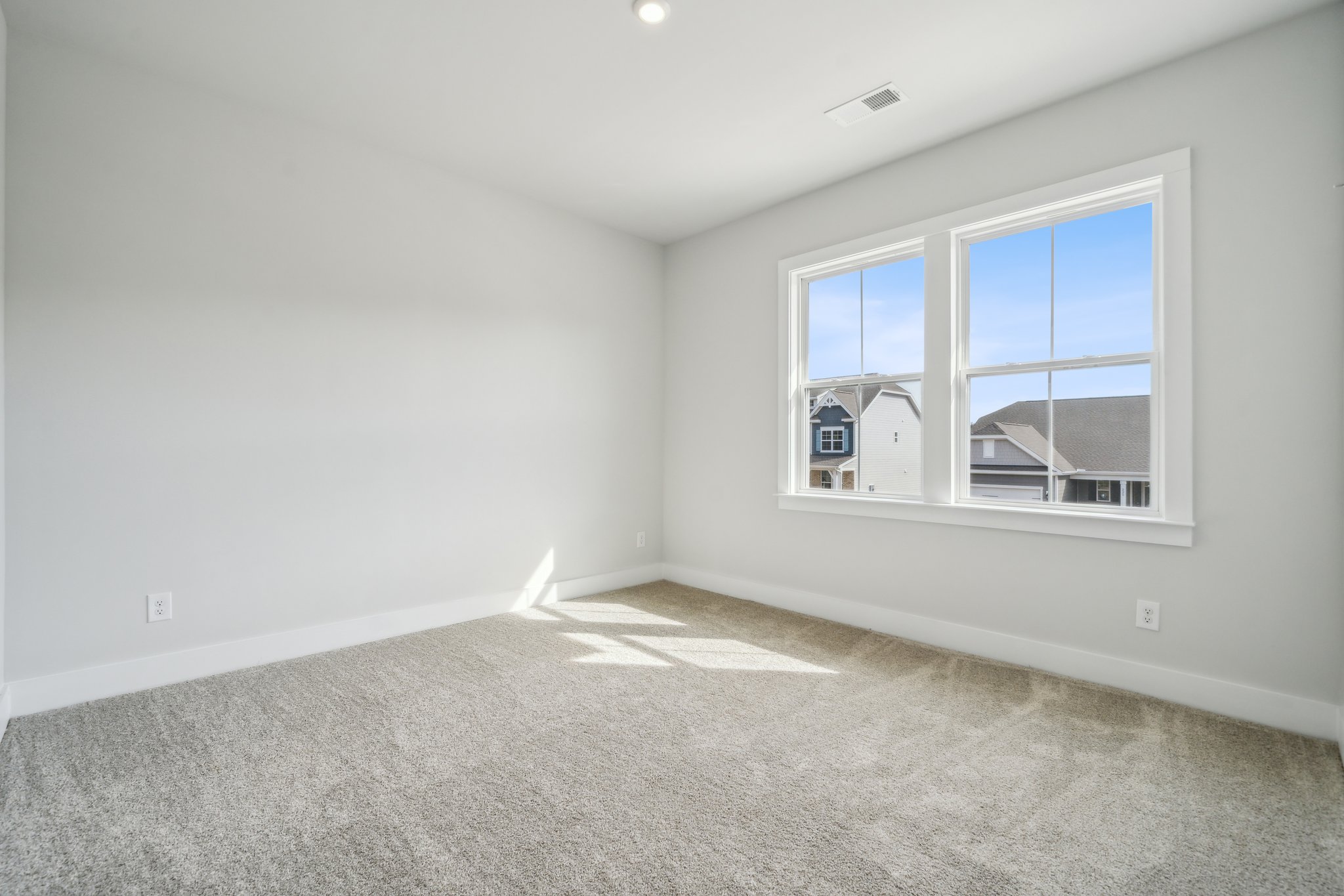 A room with a window and a rug.