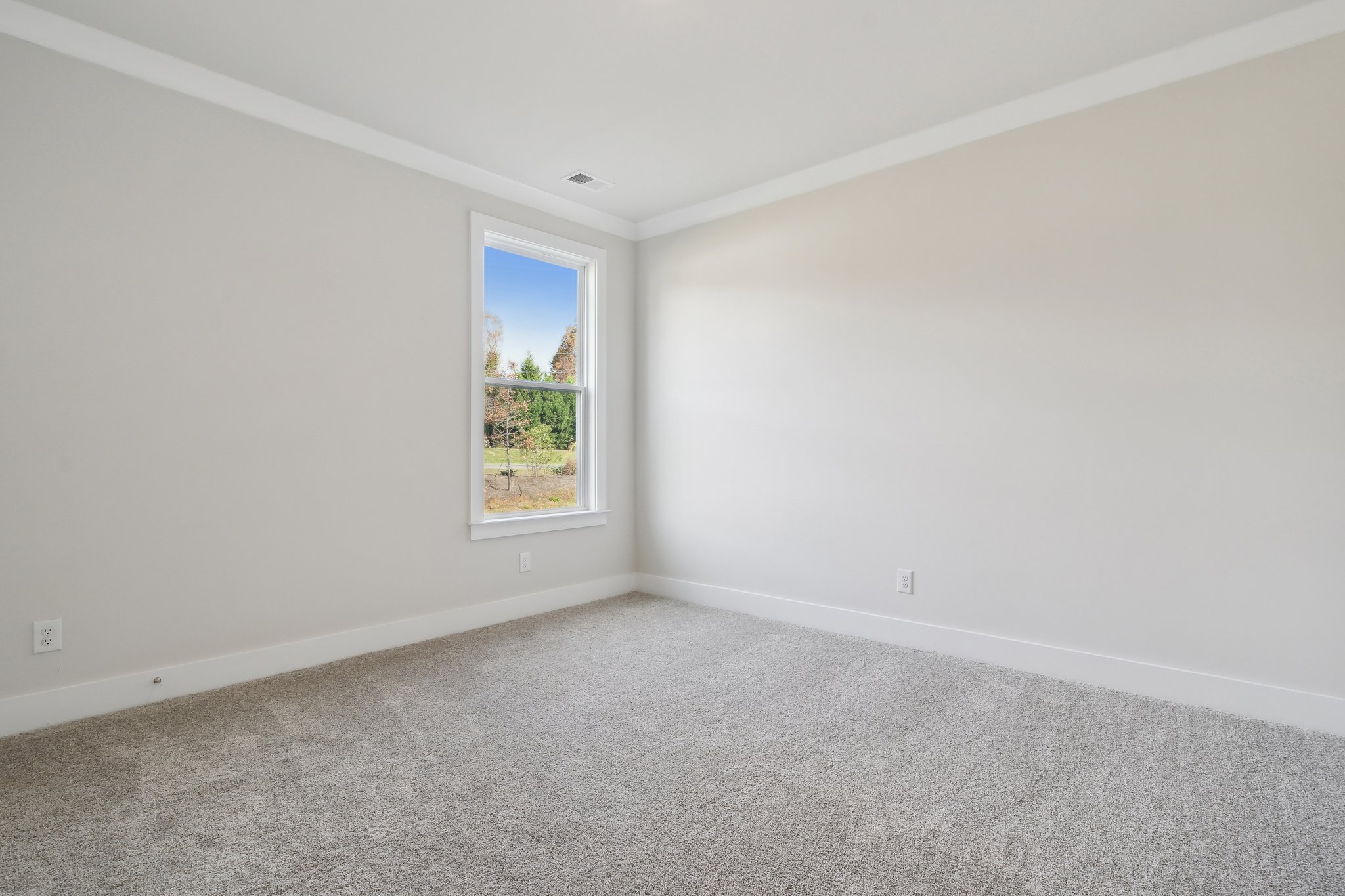 A room with a window and a carpet.