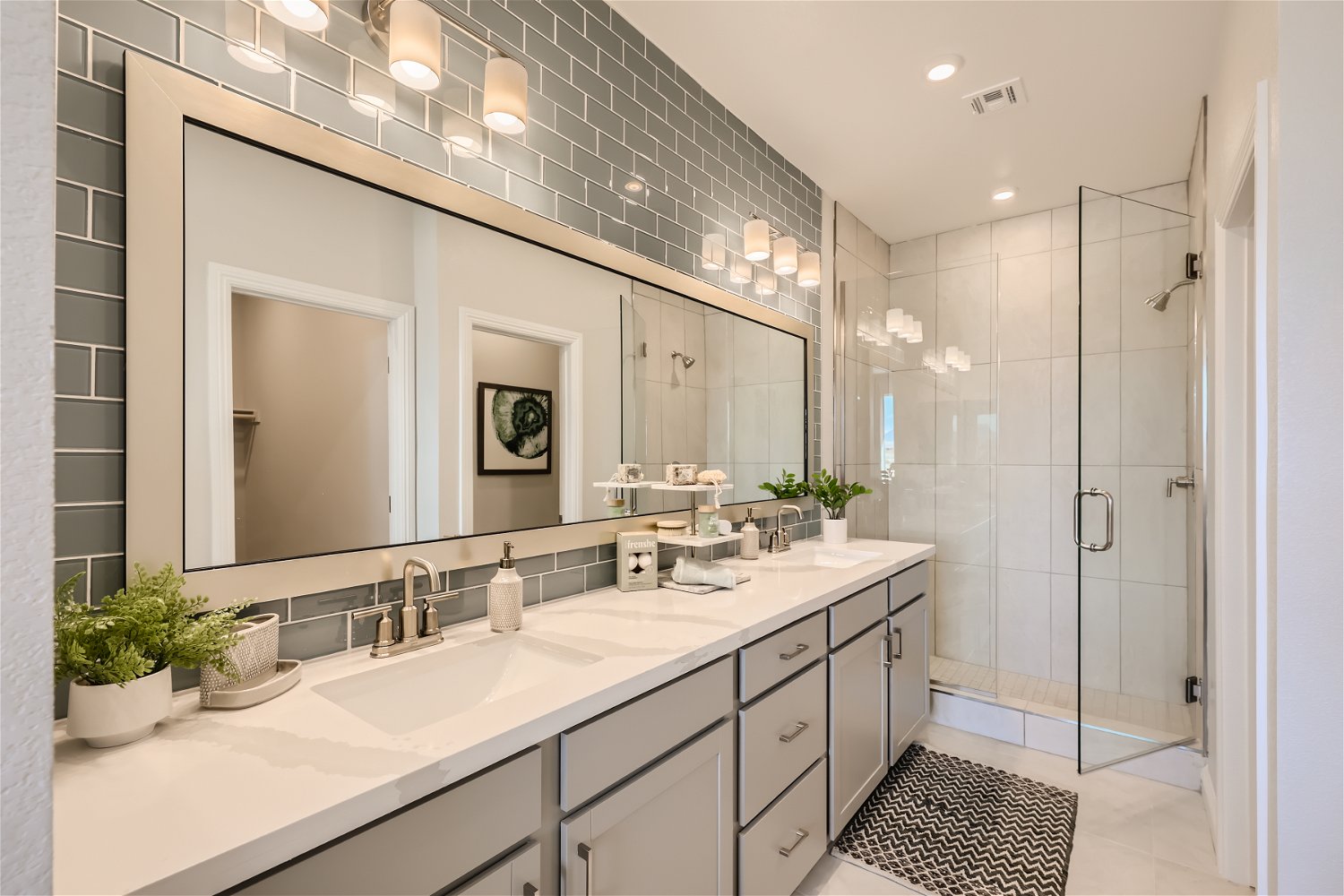 A bathroom with a large mirror.
