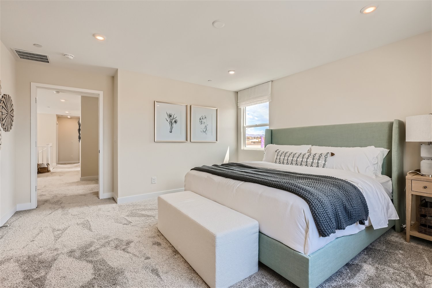 A bedroom with a bed and a bench.