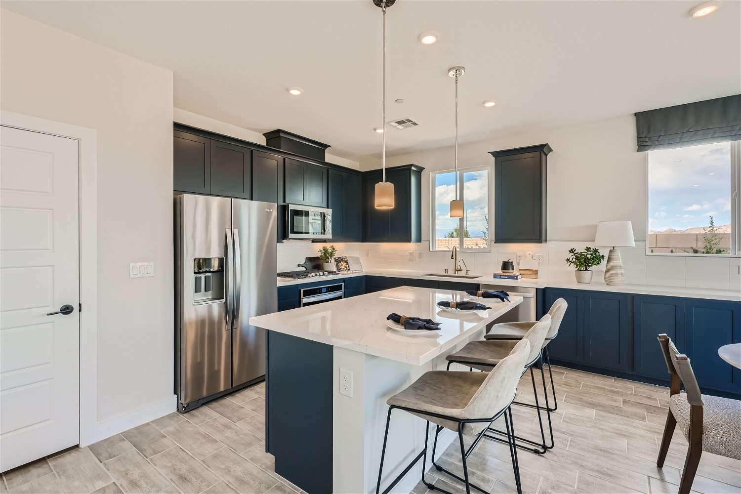 A kitchen with a bar and chairs.
