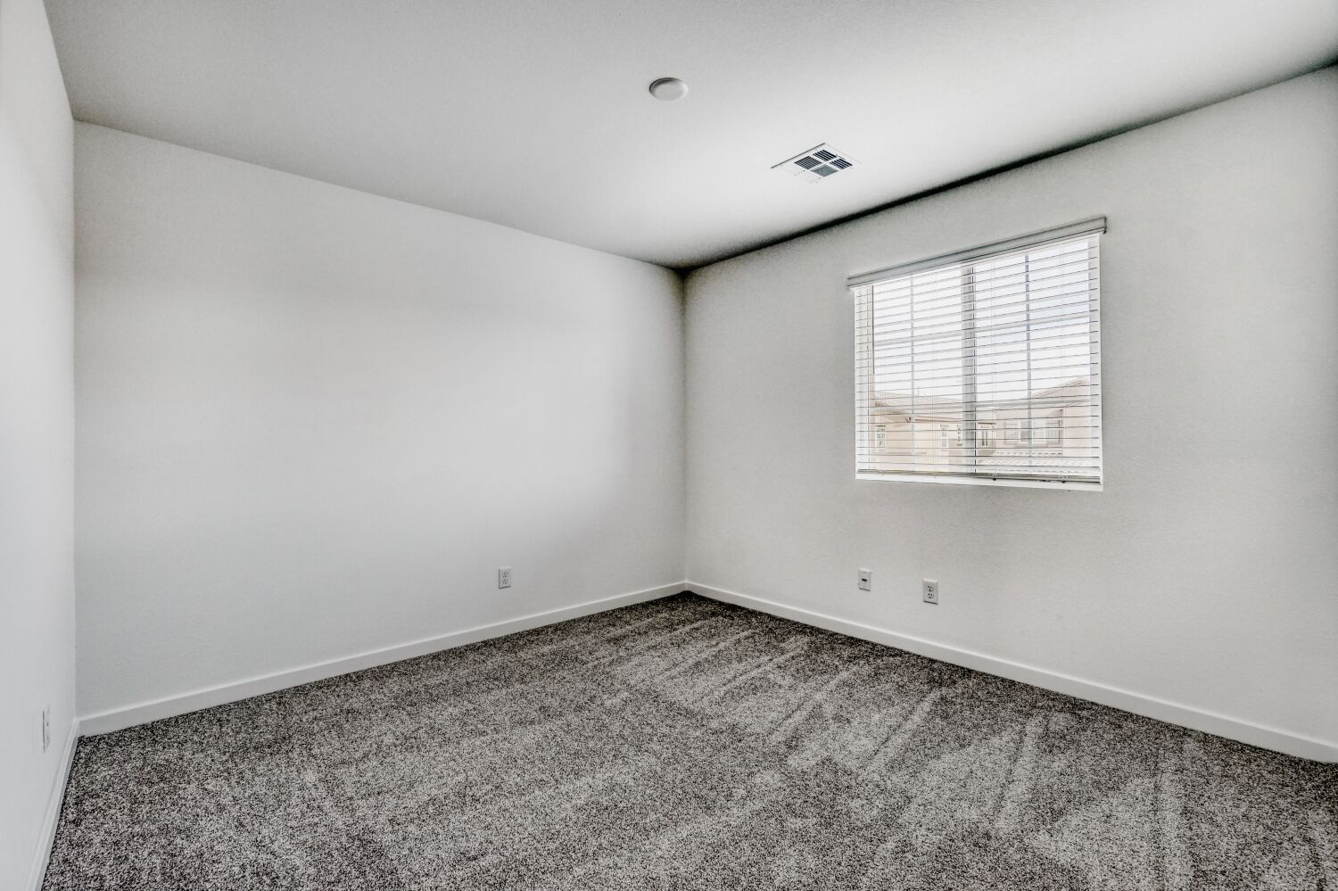 A room with a window and carpet.