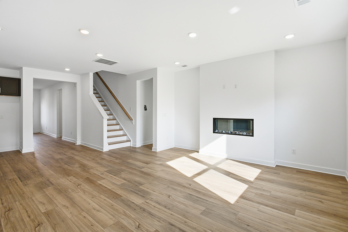 A large empty room with a staircase.