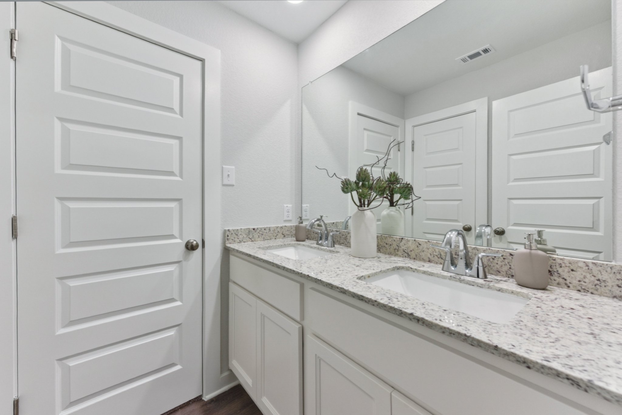 A bathroom with white cabinets.