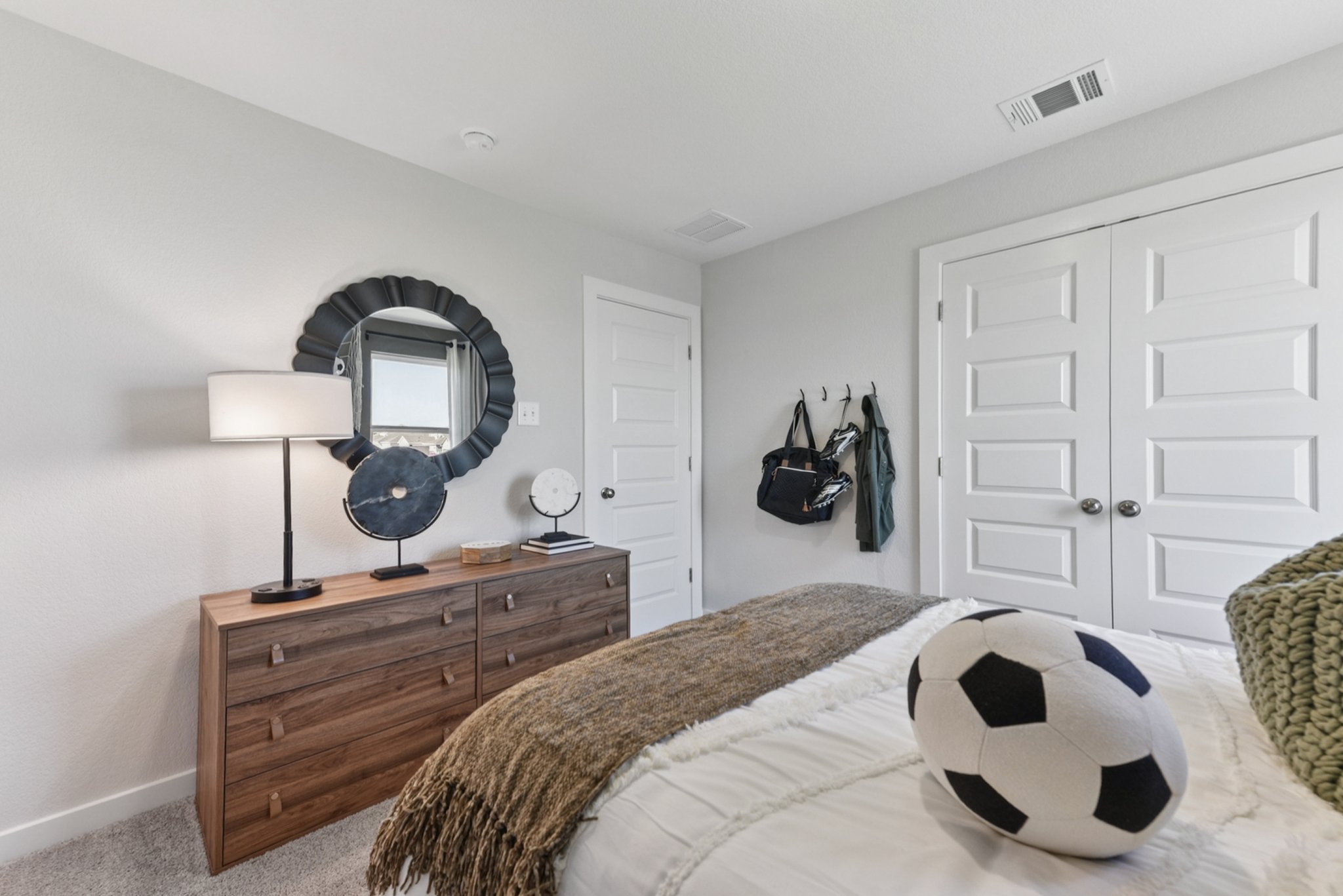 A bedroom with a mirror and a bed.