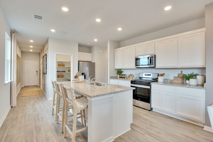 A kitchen with white cabinets.