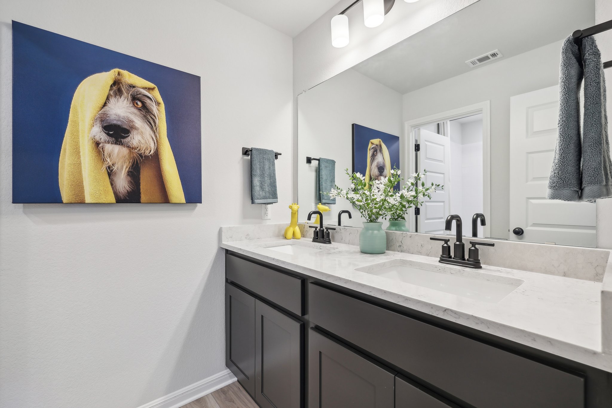 A bathroom with a painting on the wall.