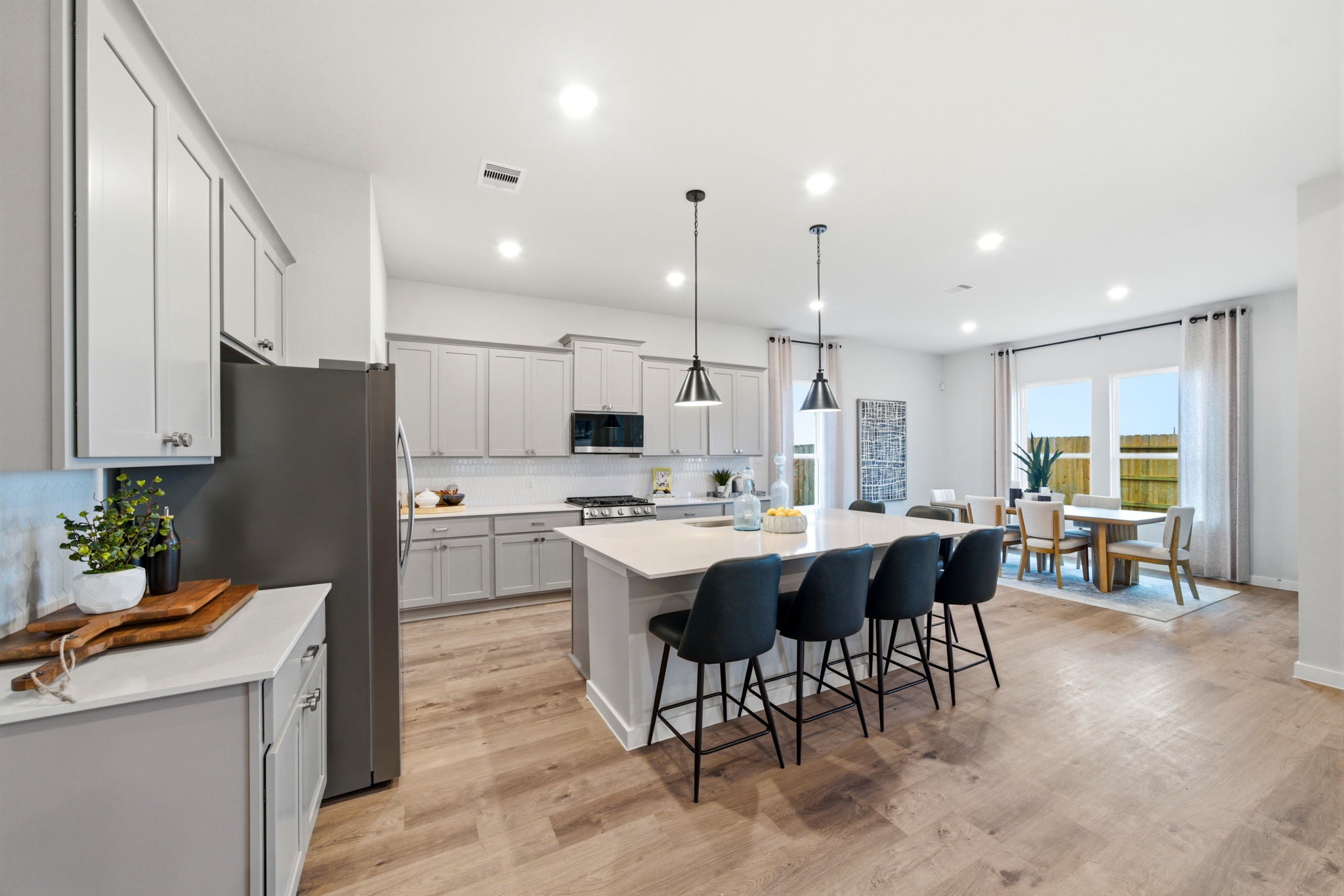 A kitchen with a dining table and chairs.