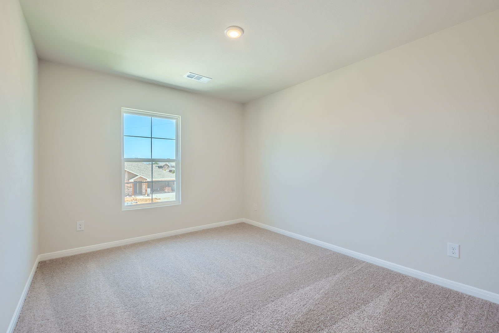 A room with a window and a carpet.