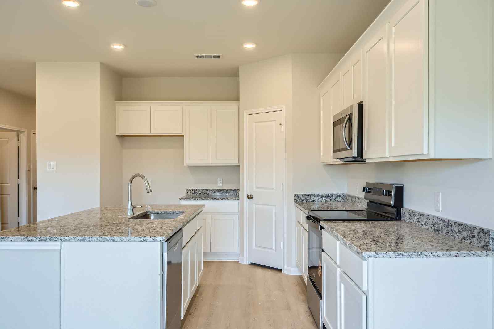 A kitchen with white cabinets.