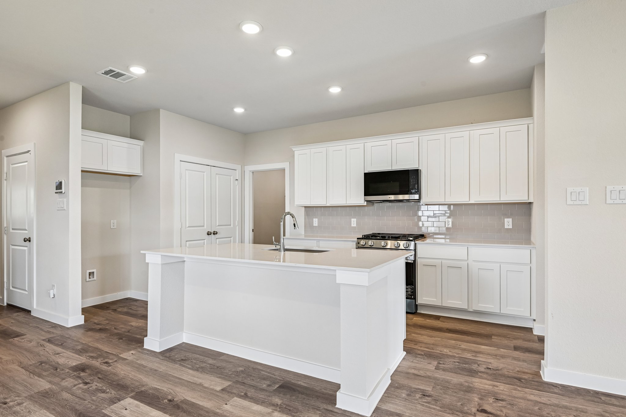 A kitchen with white cabinets.