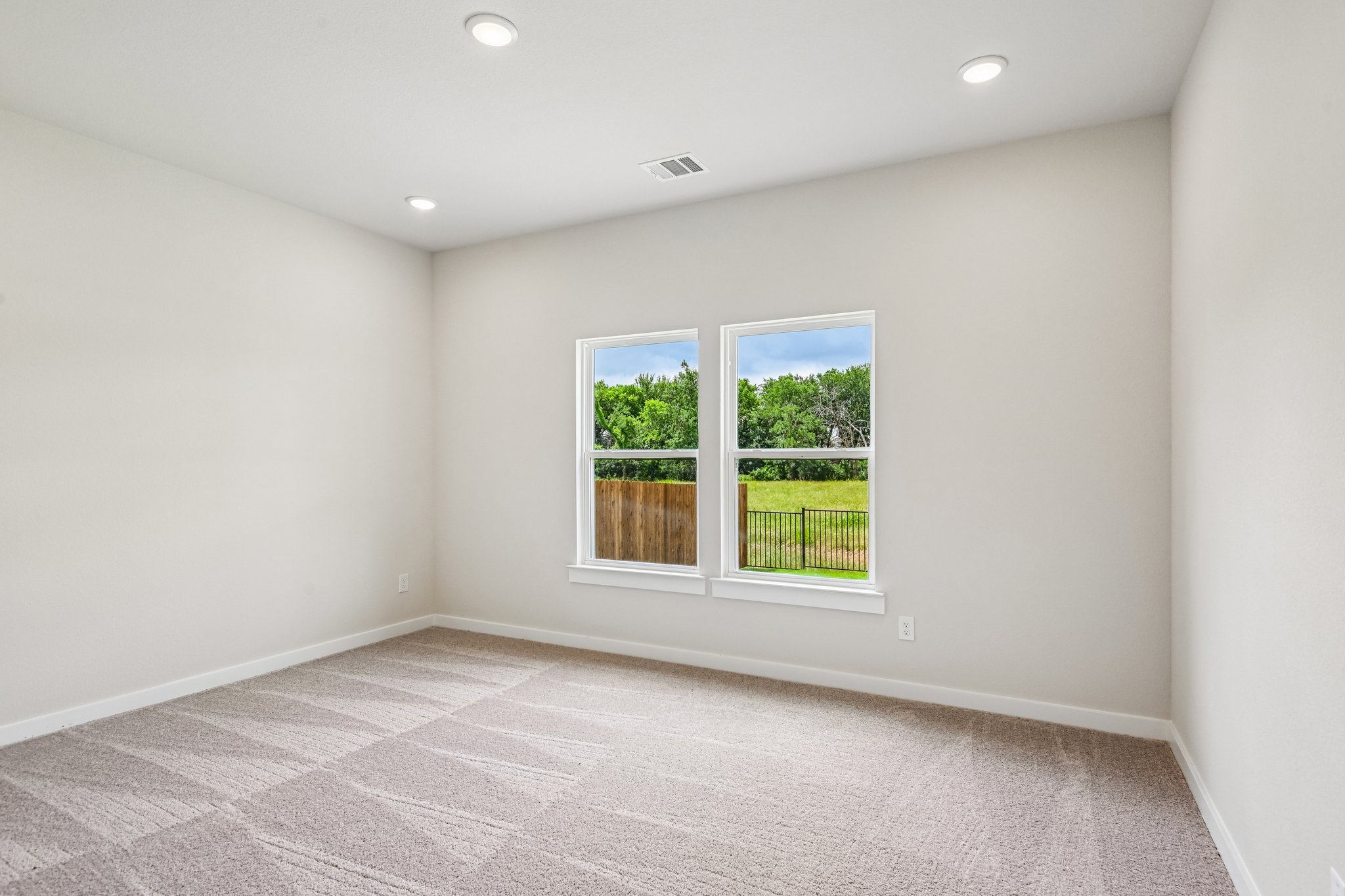 A room with a window and a carpet.