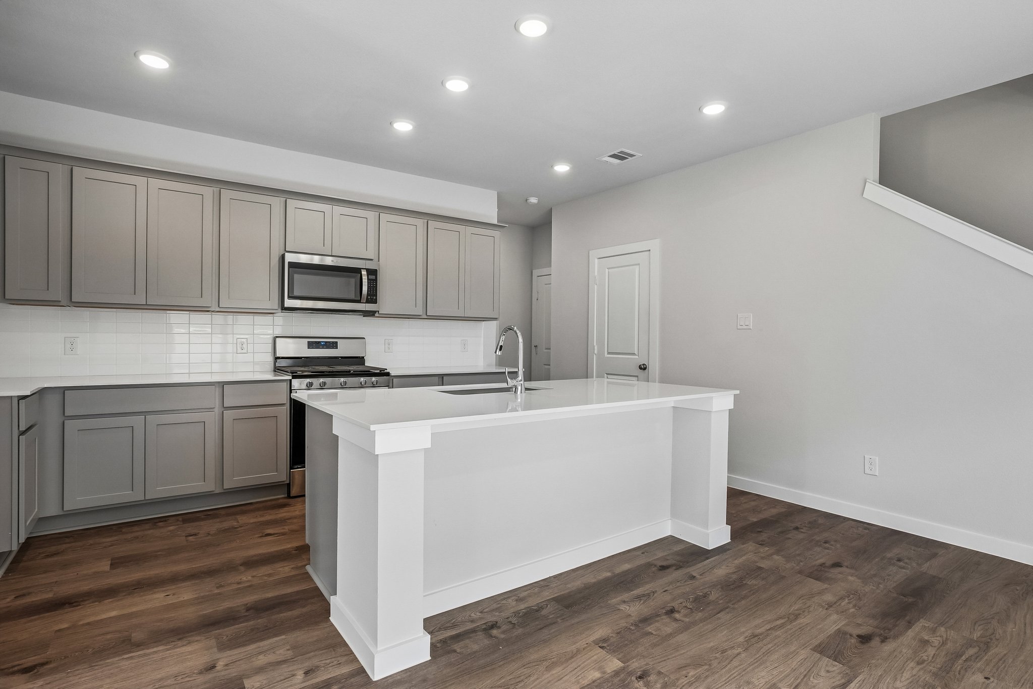 A kitchen with white cabinets.