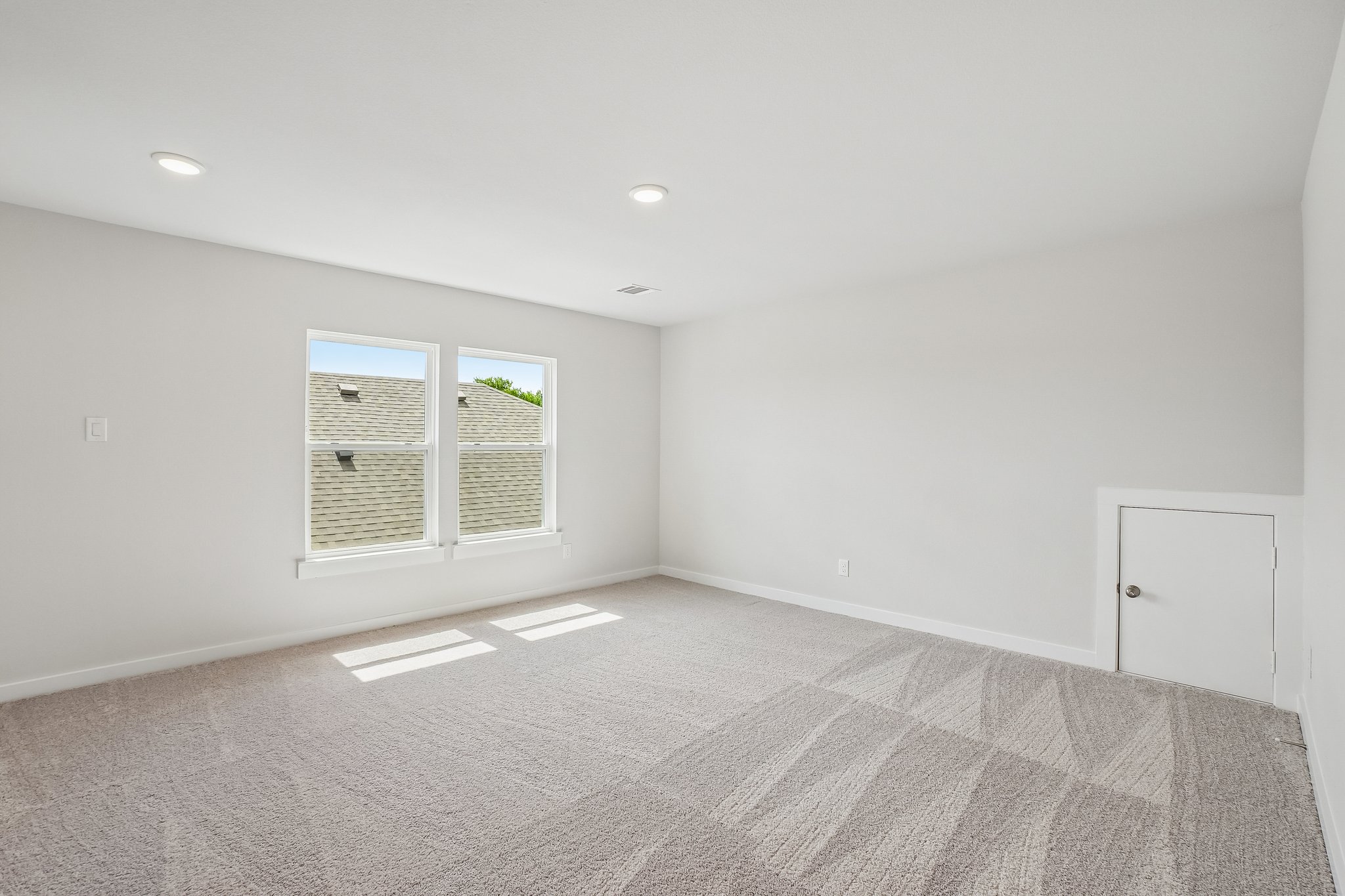 A room with a carpet and windows.