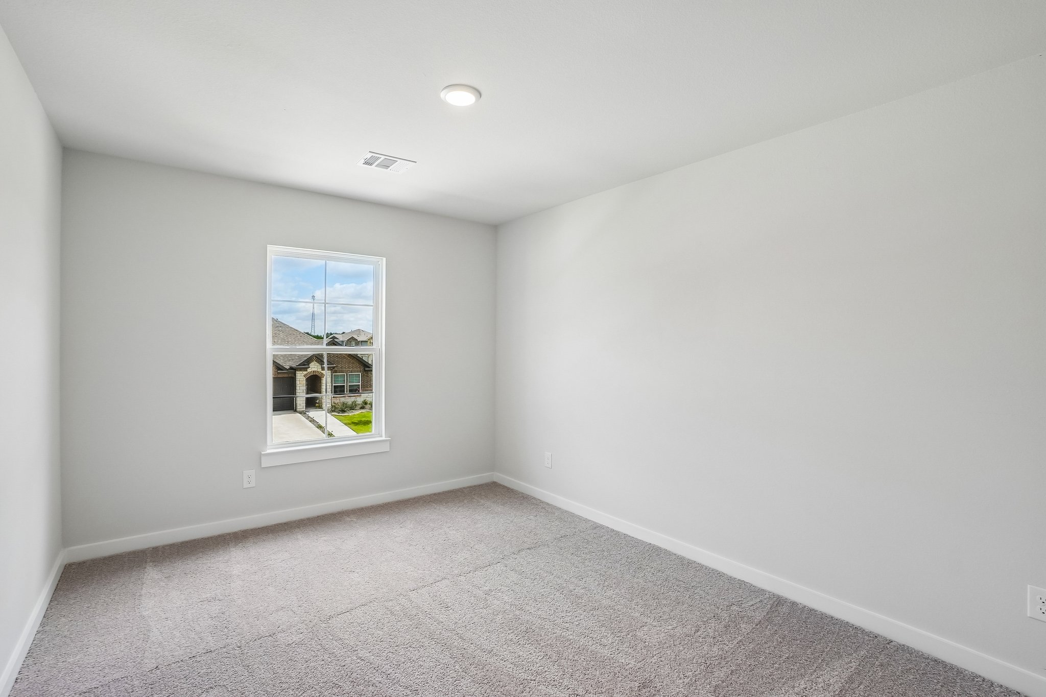 A room with a window and carpet.