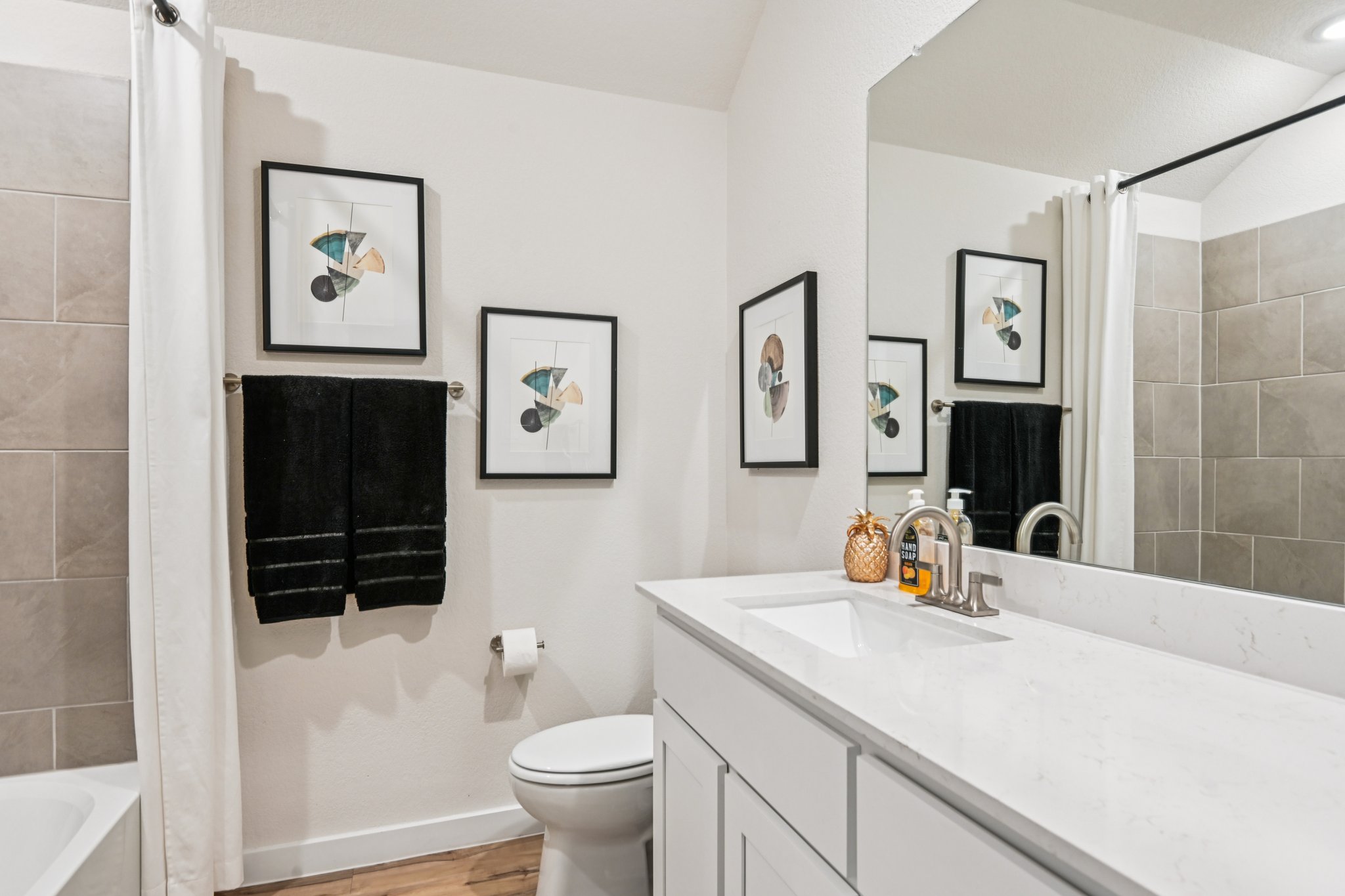 A bathroom with a sink toilet and mirror.