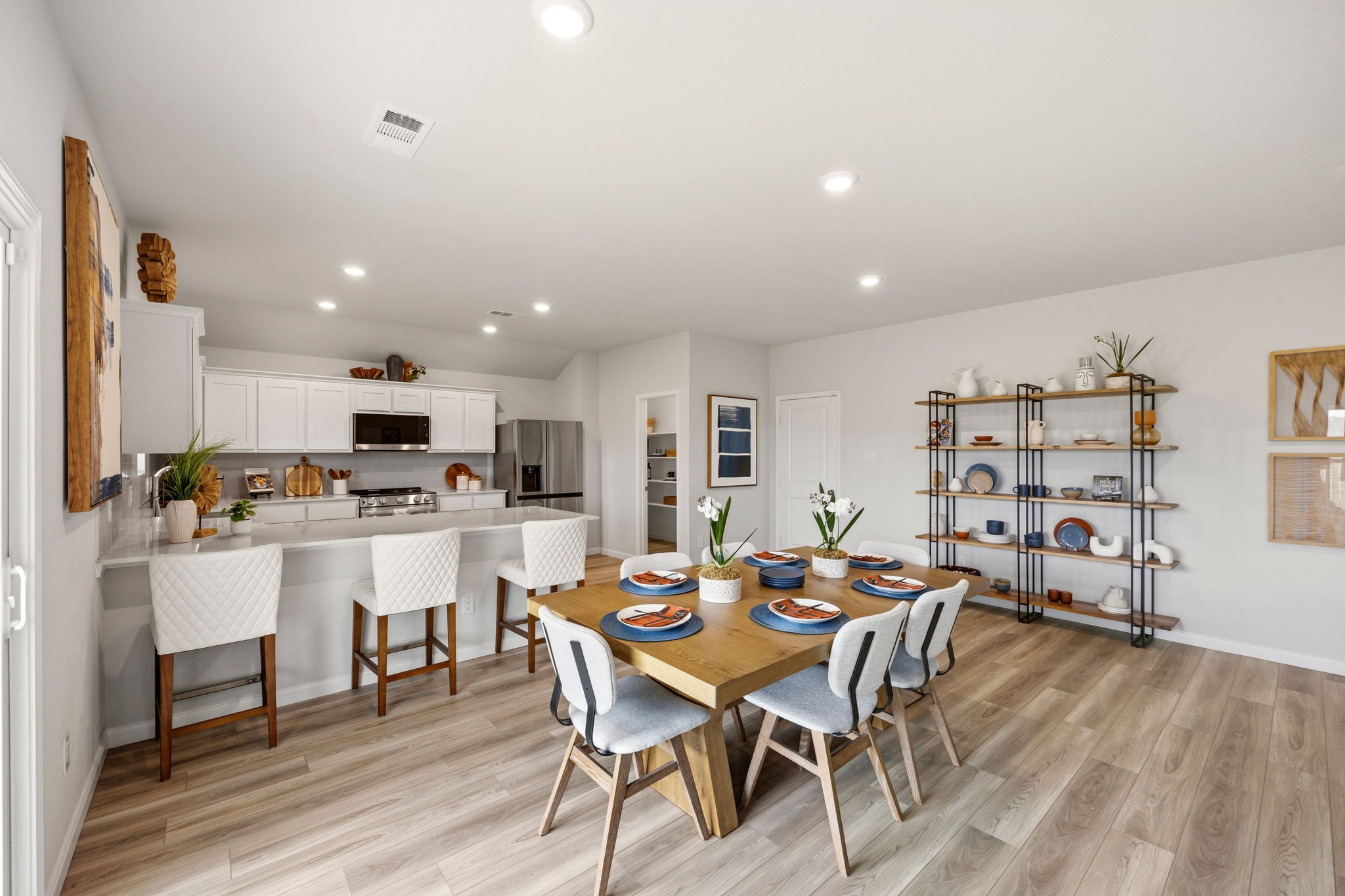 A kitchen with a dining table and chairs.