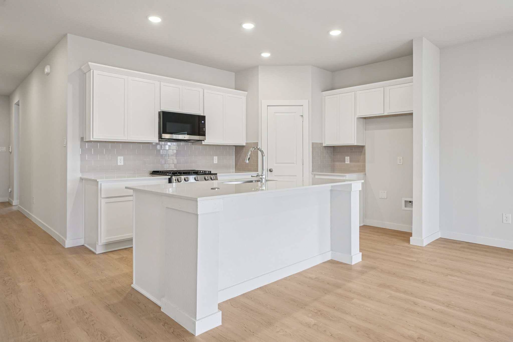 A kitchen with white cabinets.