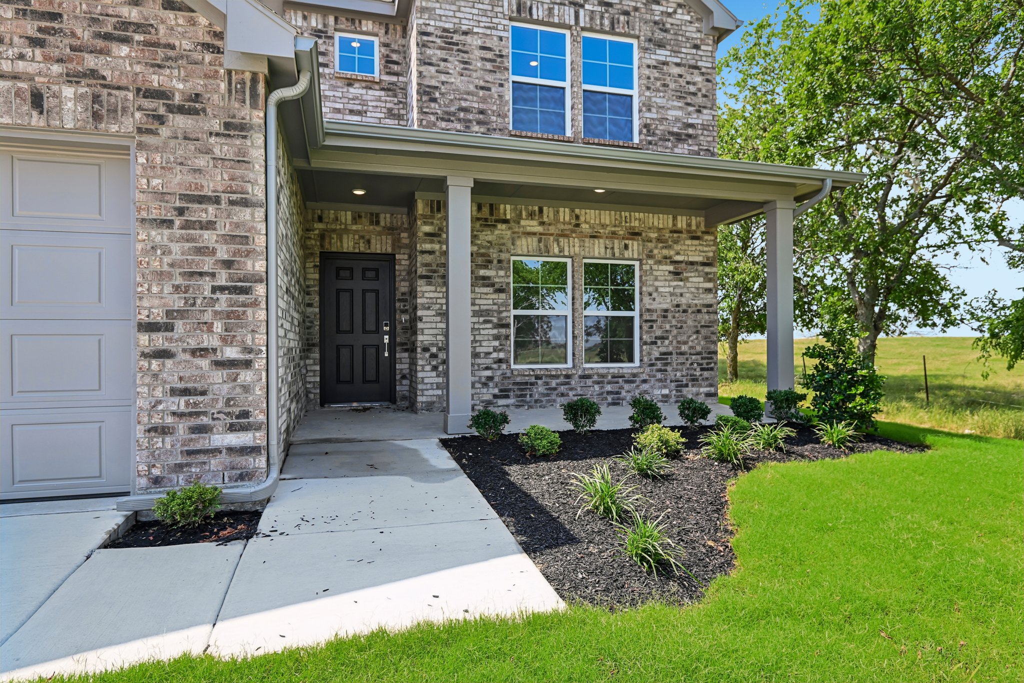 A brick house with a front yard.