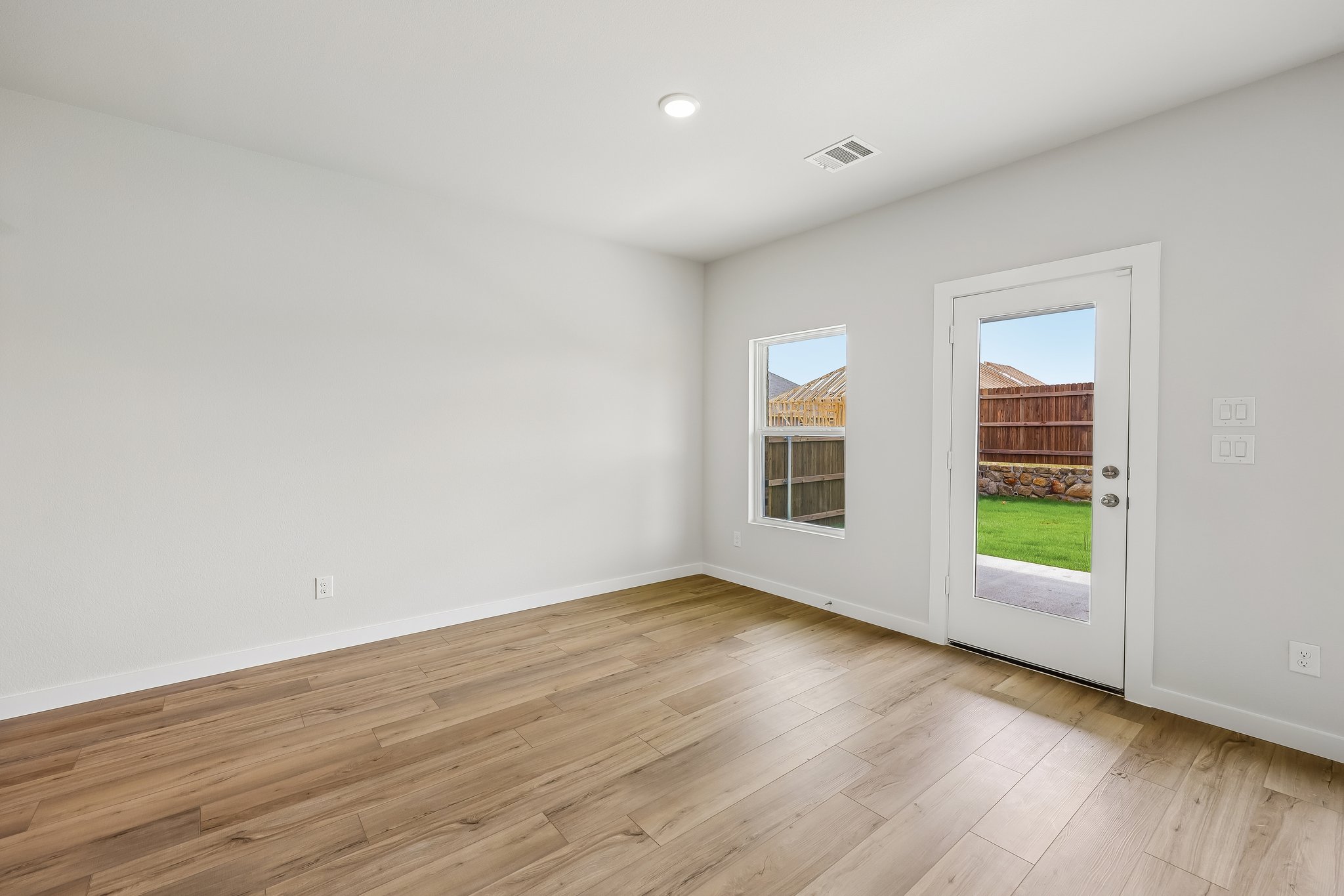 A room with a wood floor and a wood floor with a window.
