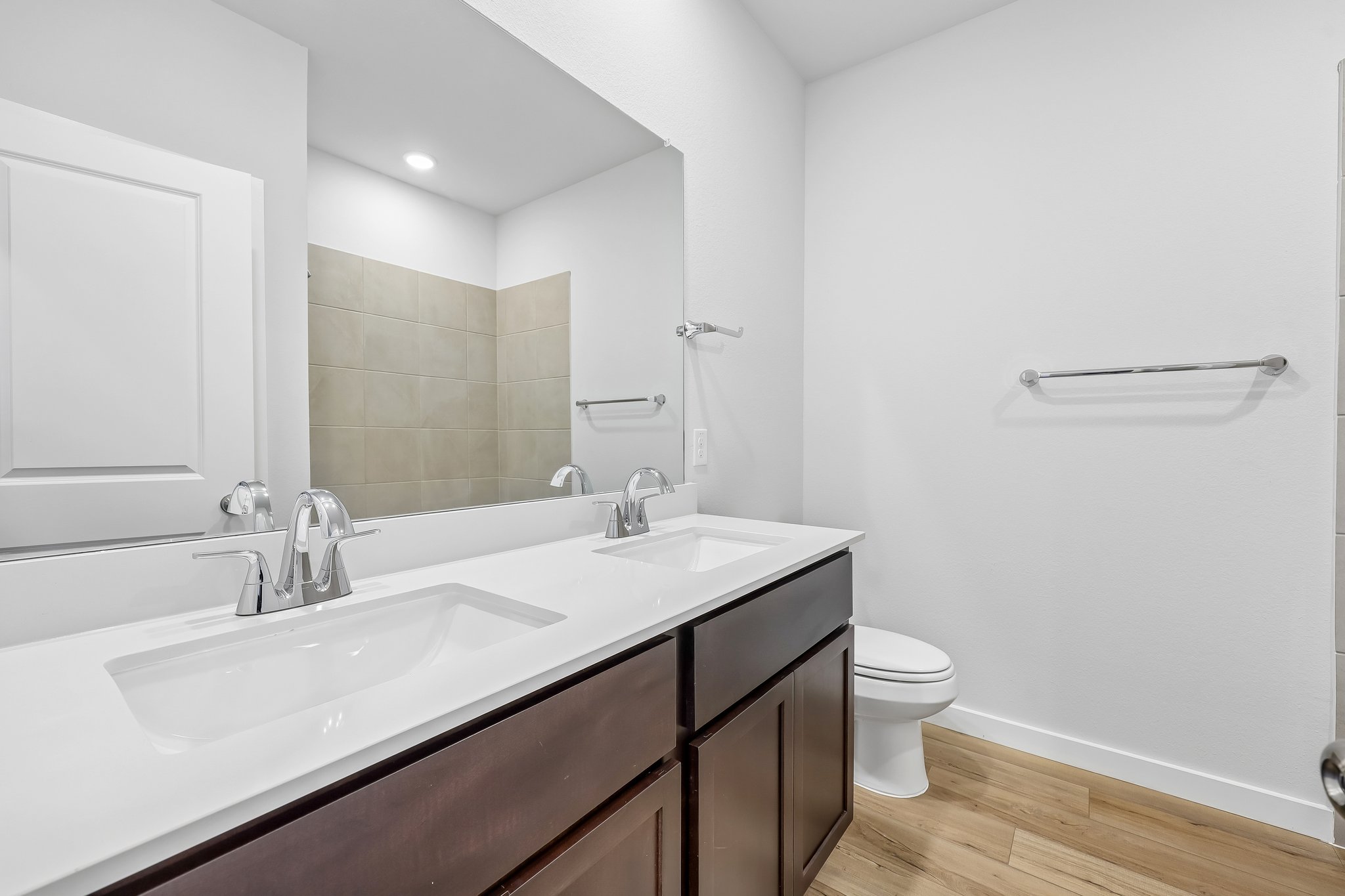 A bathroom with a sink toilet and mirror.