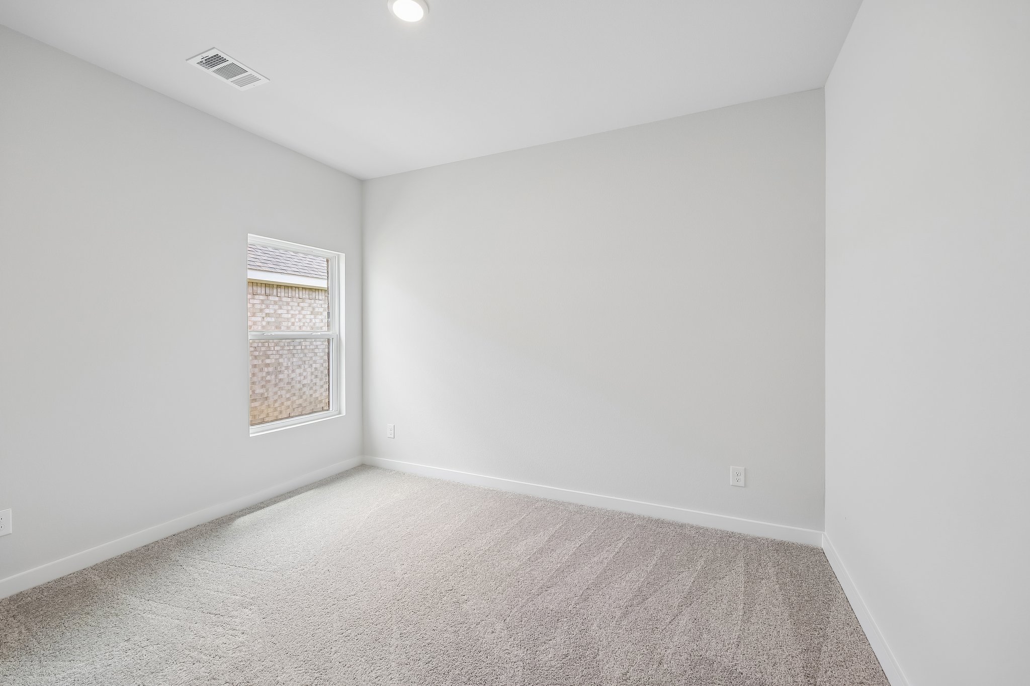 A room with a carpet and a window.