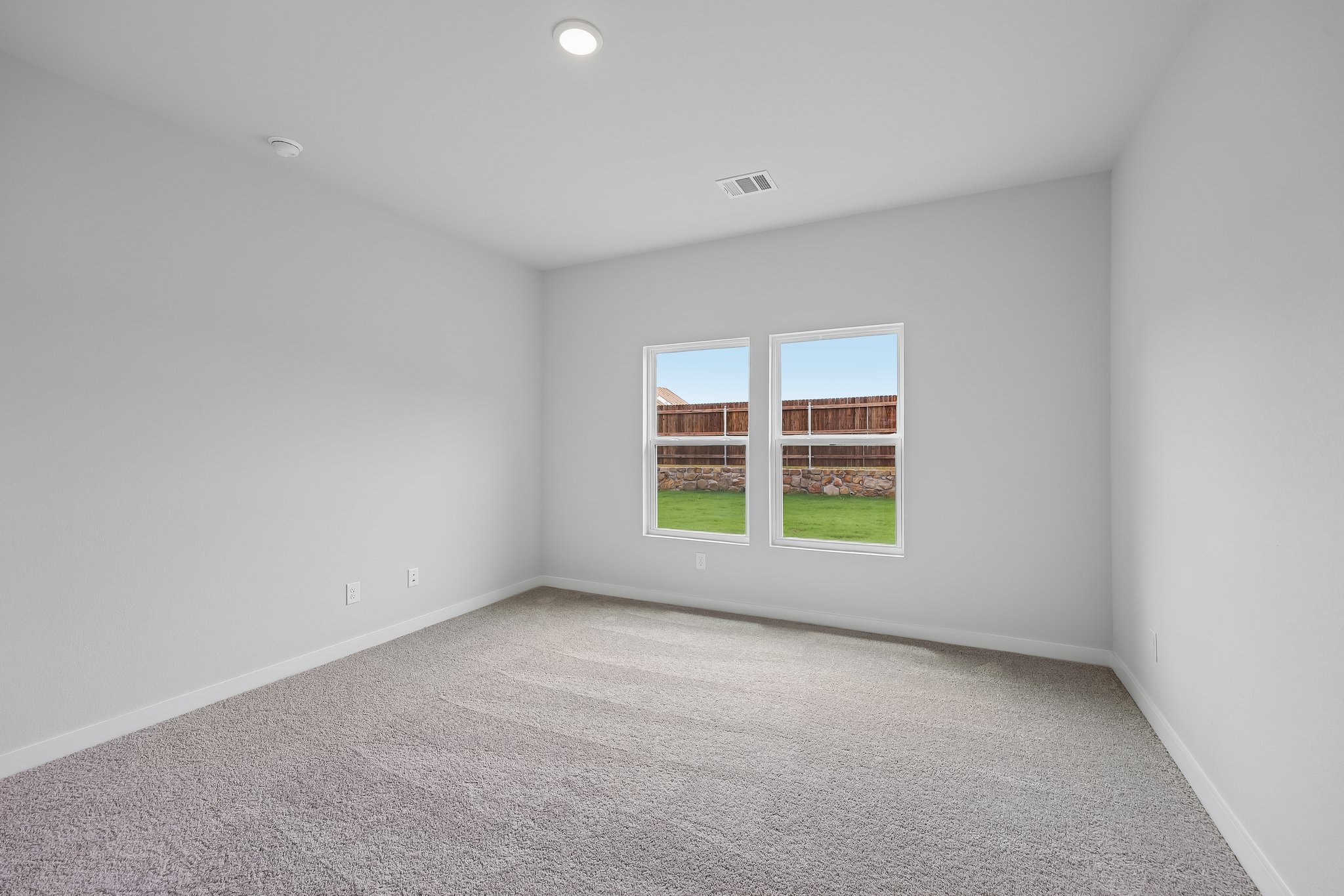 A room with a window and a carpet.