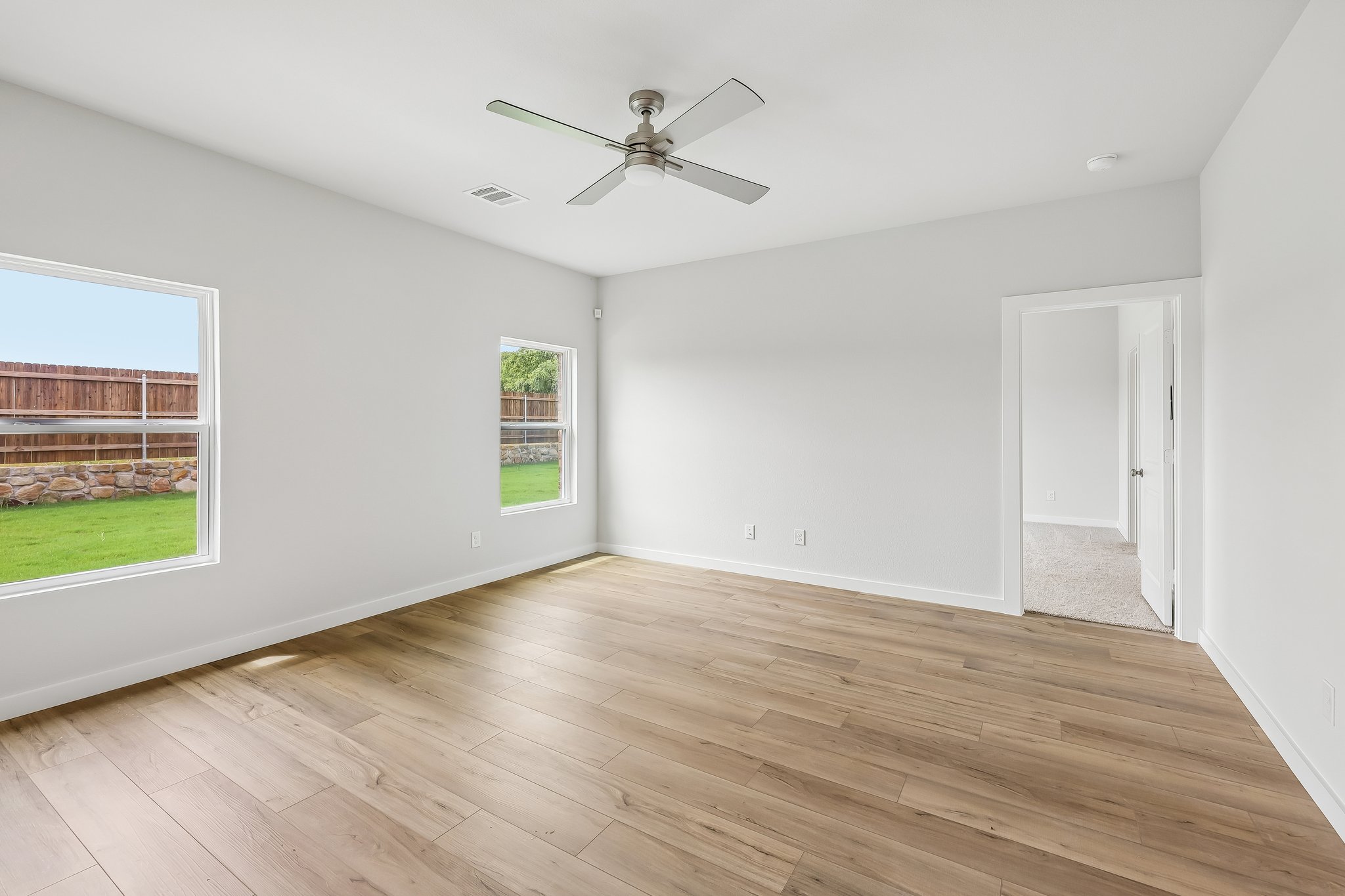 A room with a wood floor and a ceiling fan.