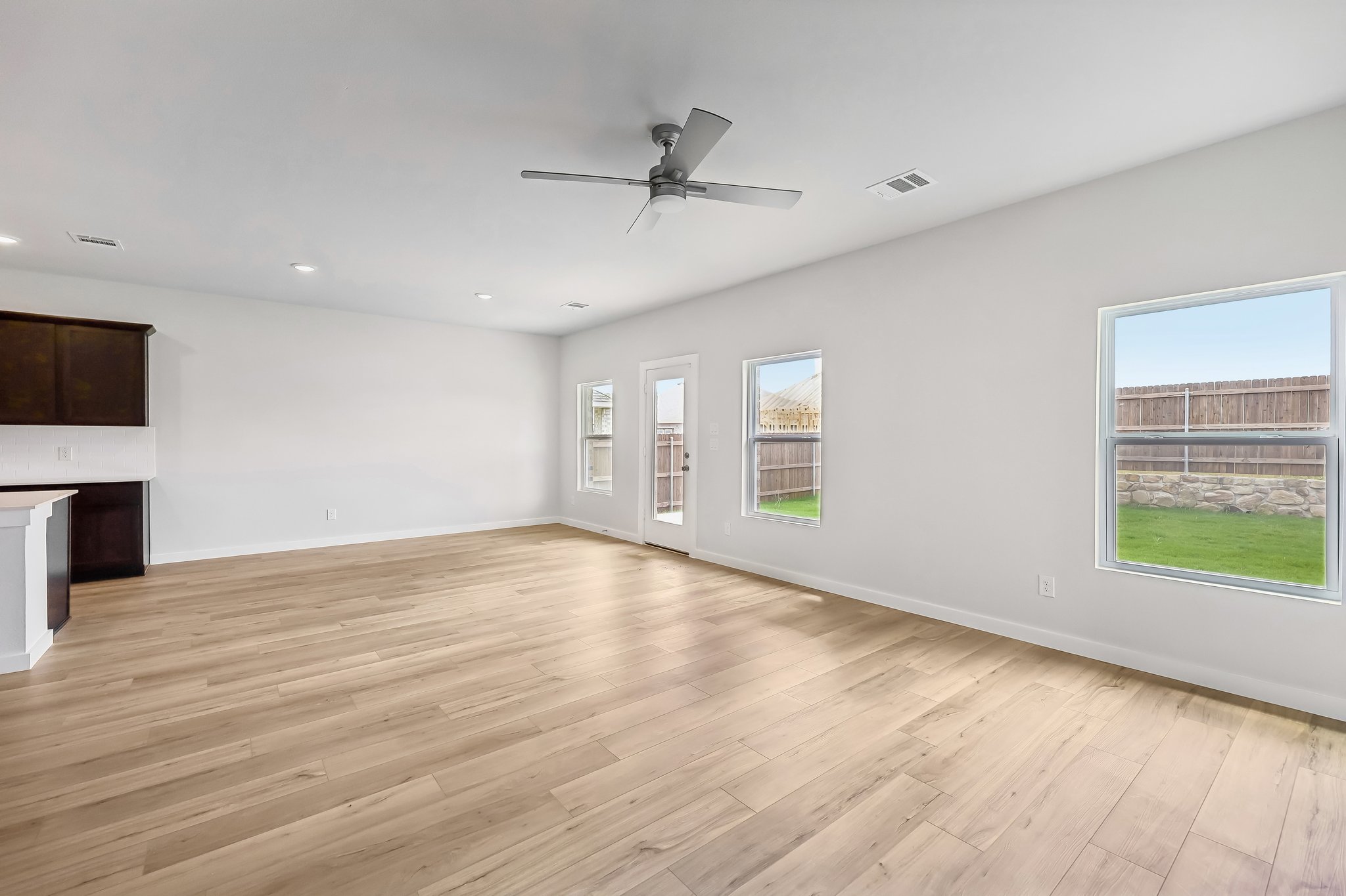 A room with a wood floor and a wood floor with a ceiling fan.