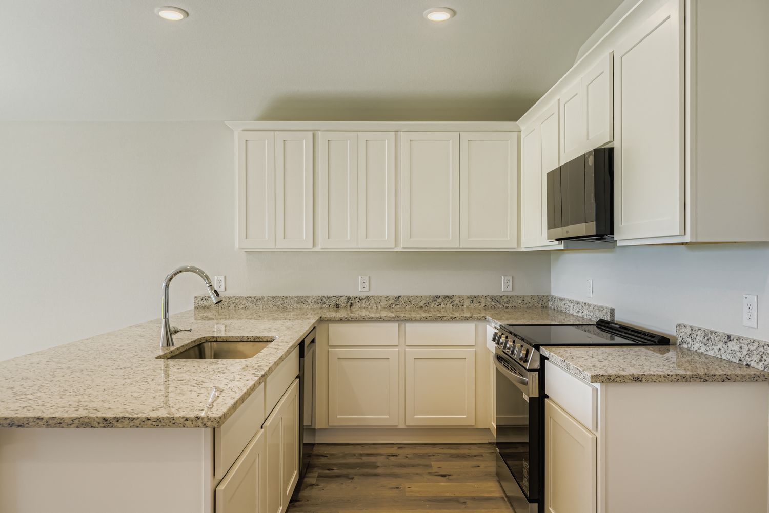 A kitchen with white cabinets.