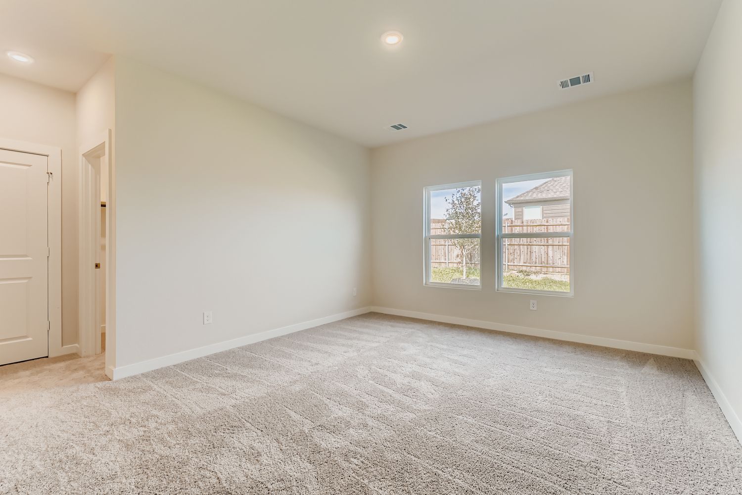 A room with a carpet and windows.