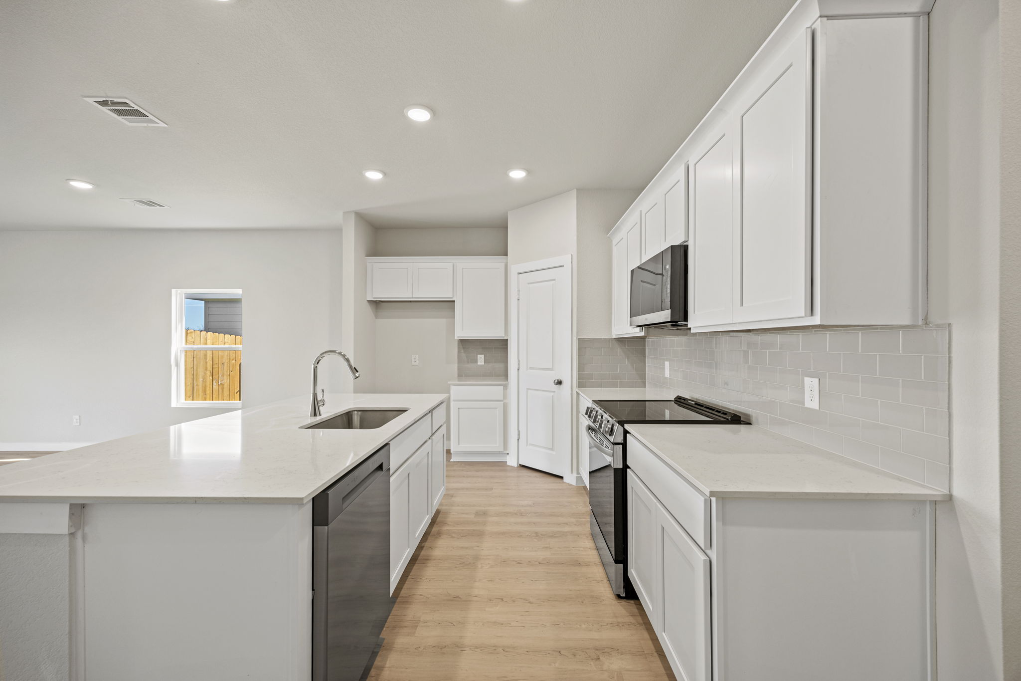 A kitchen with white cabinets.