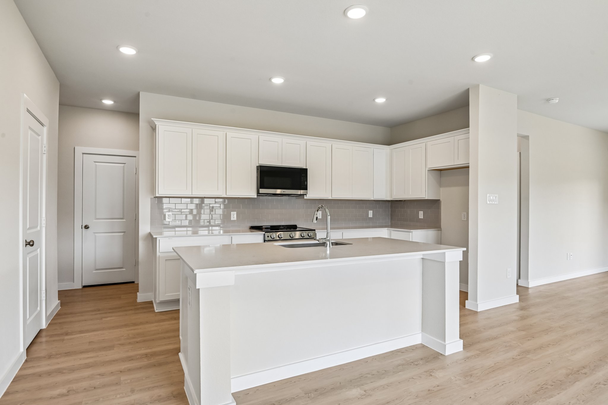 A kitchen with white cabinets.
