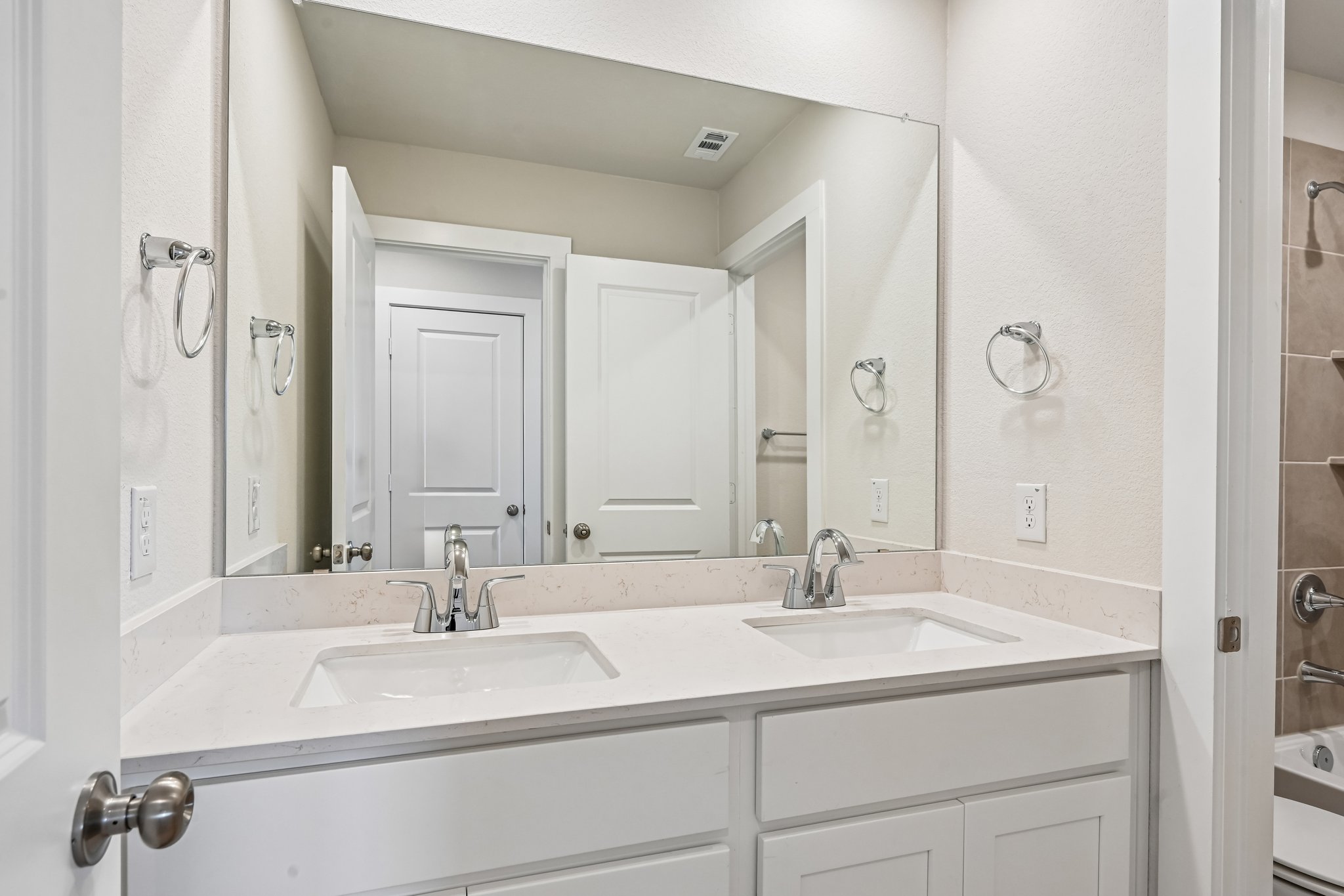 A bathroom with a large mirror.