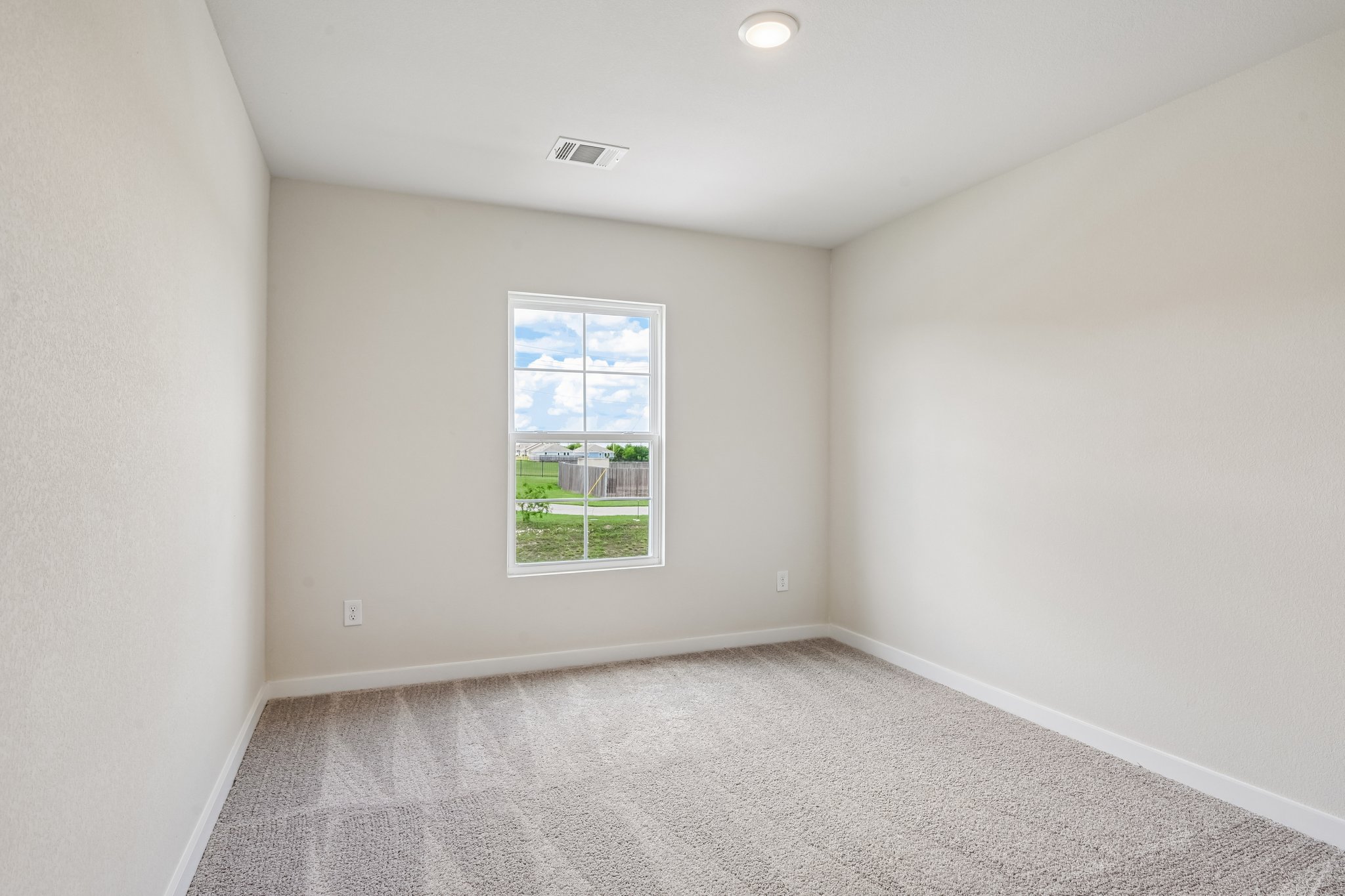 A room with a window and carpet.
