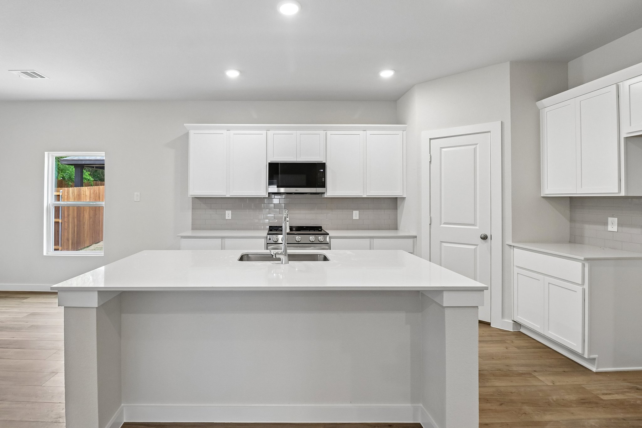 A kitchen with white cabinets.