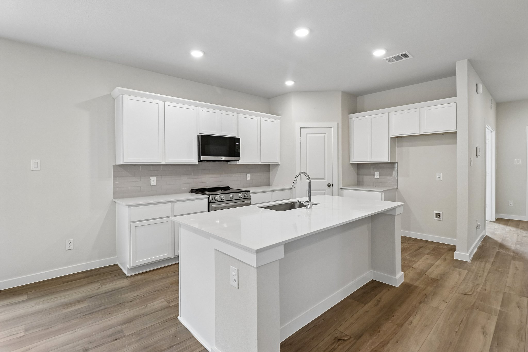 A kitchen with white cabinets.