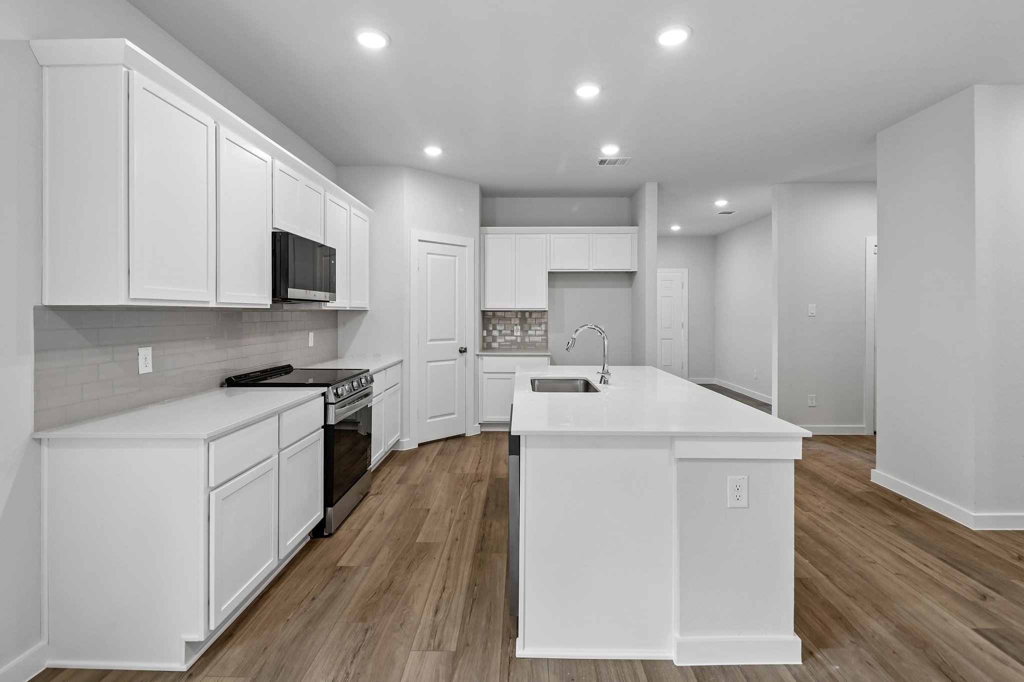 A kitchen with white cabinets.