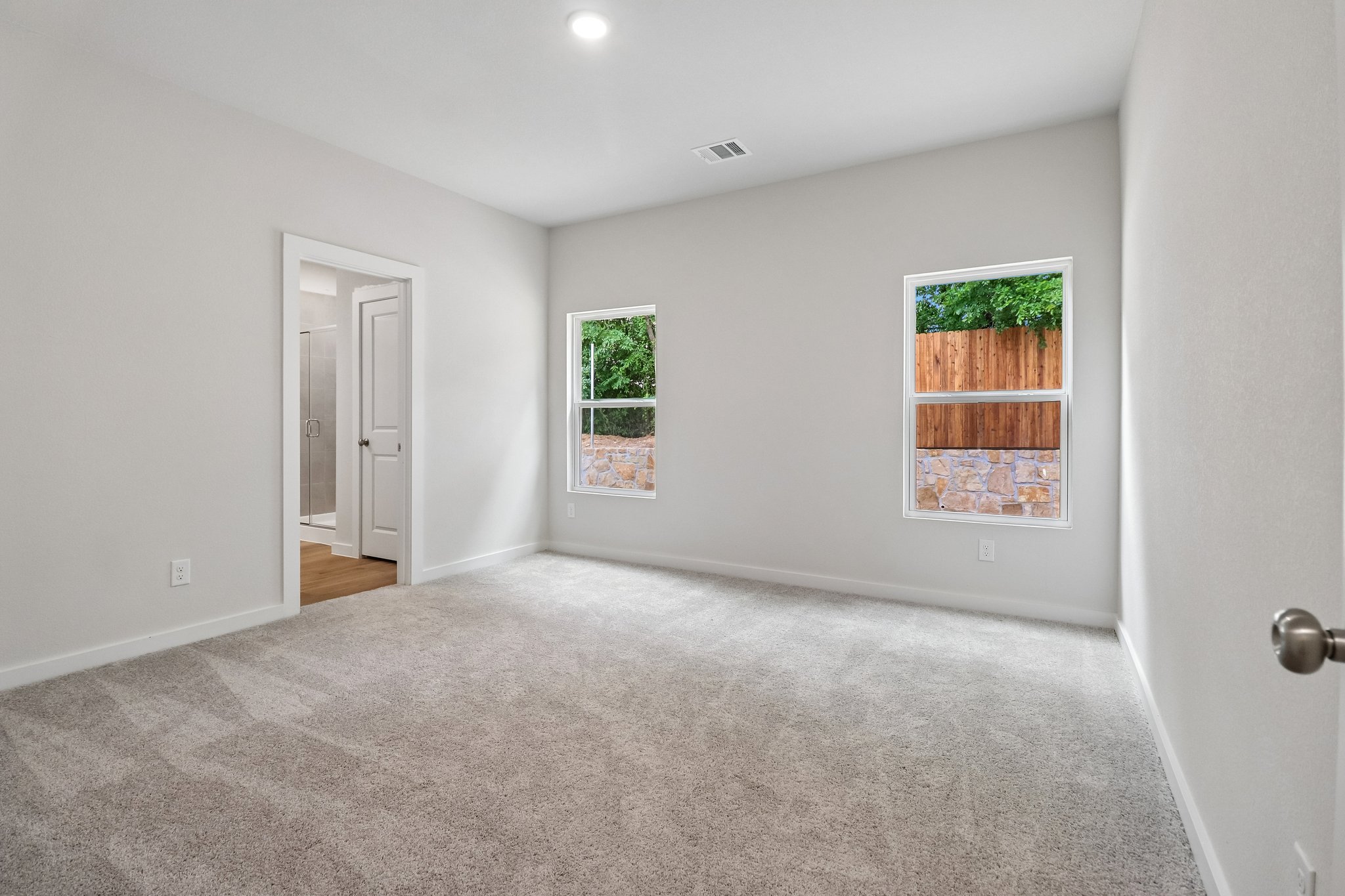A room with a carpet and a window.