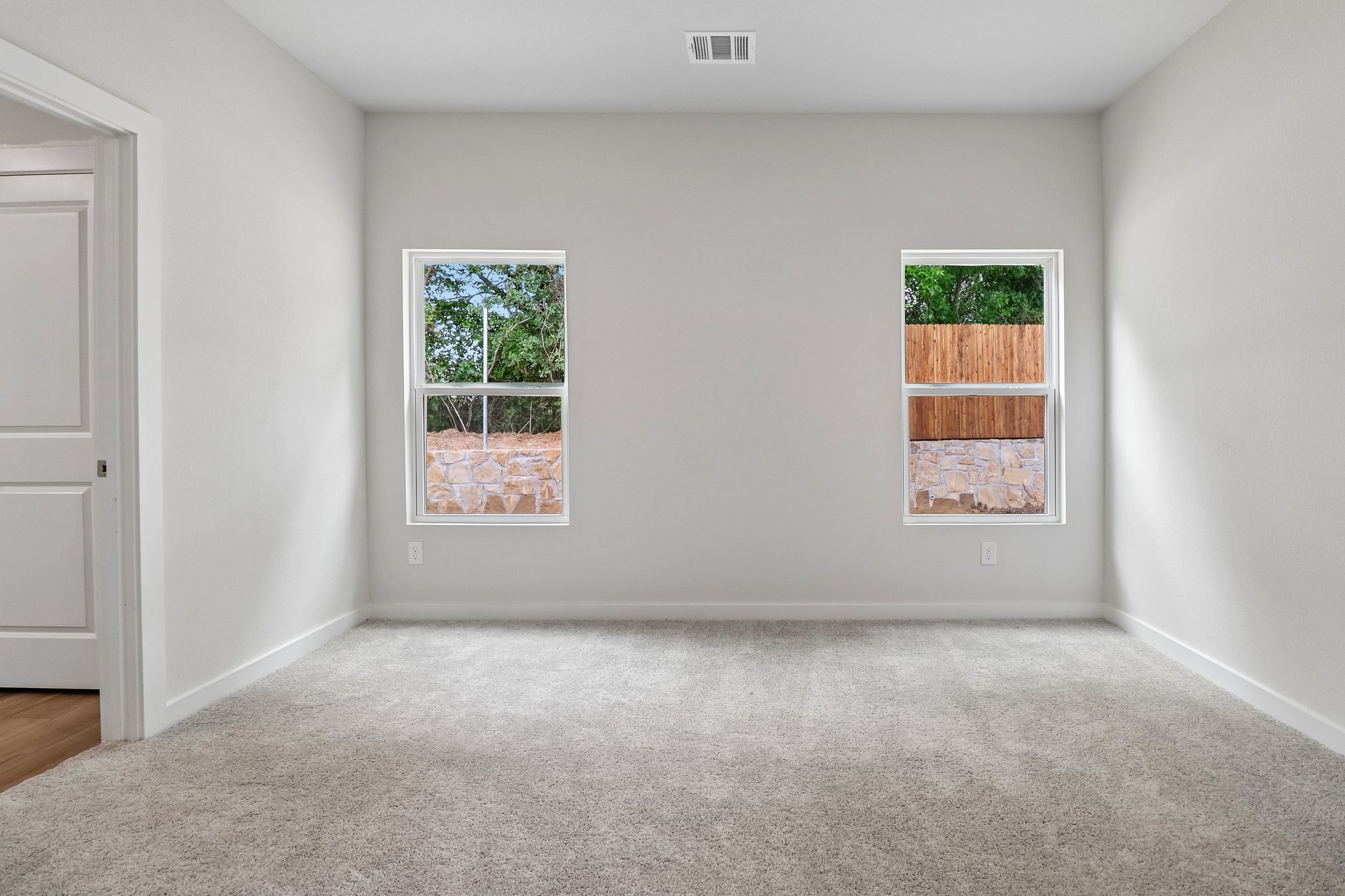 A room with a window and a rug in it.